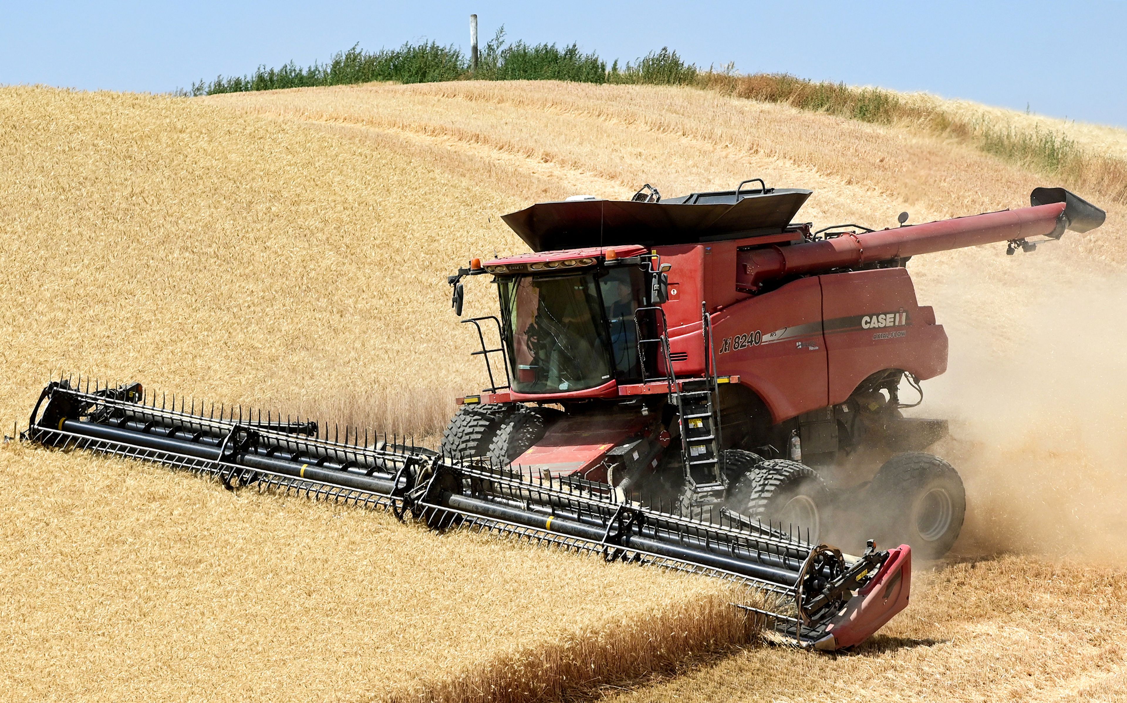 A combines moves across a field on Monday along Highway 195 north of Colfax.