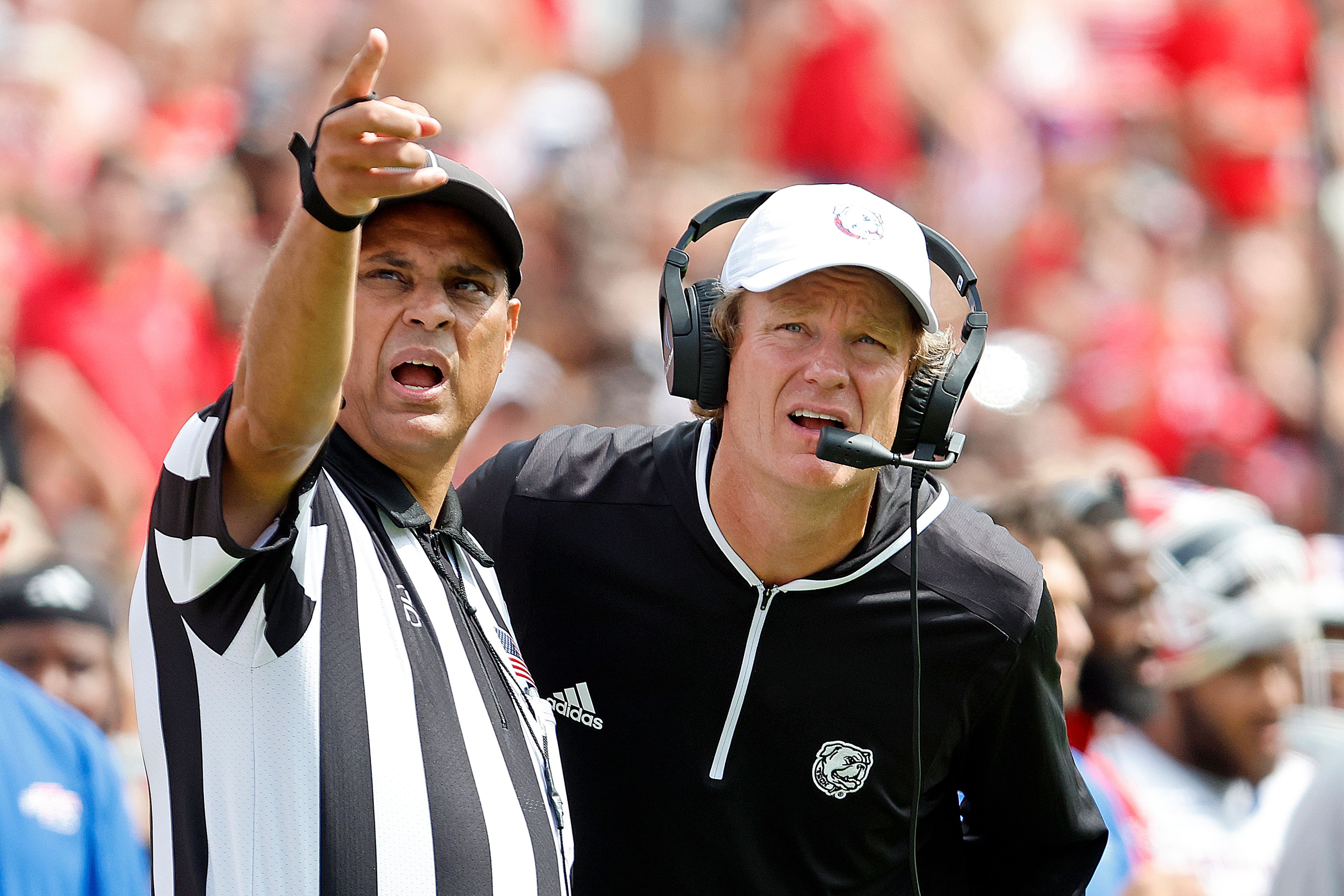 Louisiana Tech head coach Sonny Cumbie, right, discusses a play with an official during the second half of an NCAA college football game against North Carolina State in Raleigh, N.C., Saturday, Sept. 14, 2024. (AP Photo/Karl B DeBlaker)