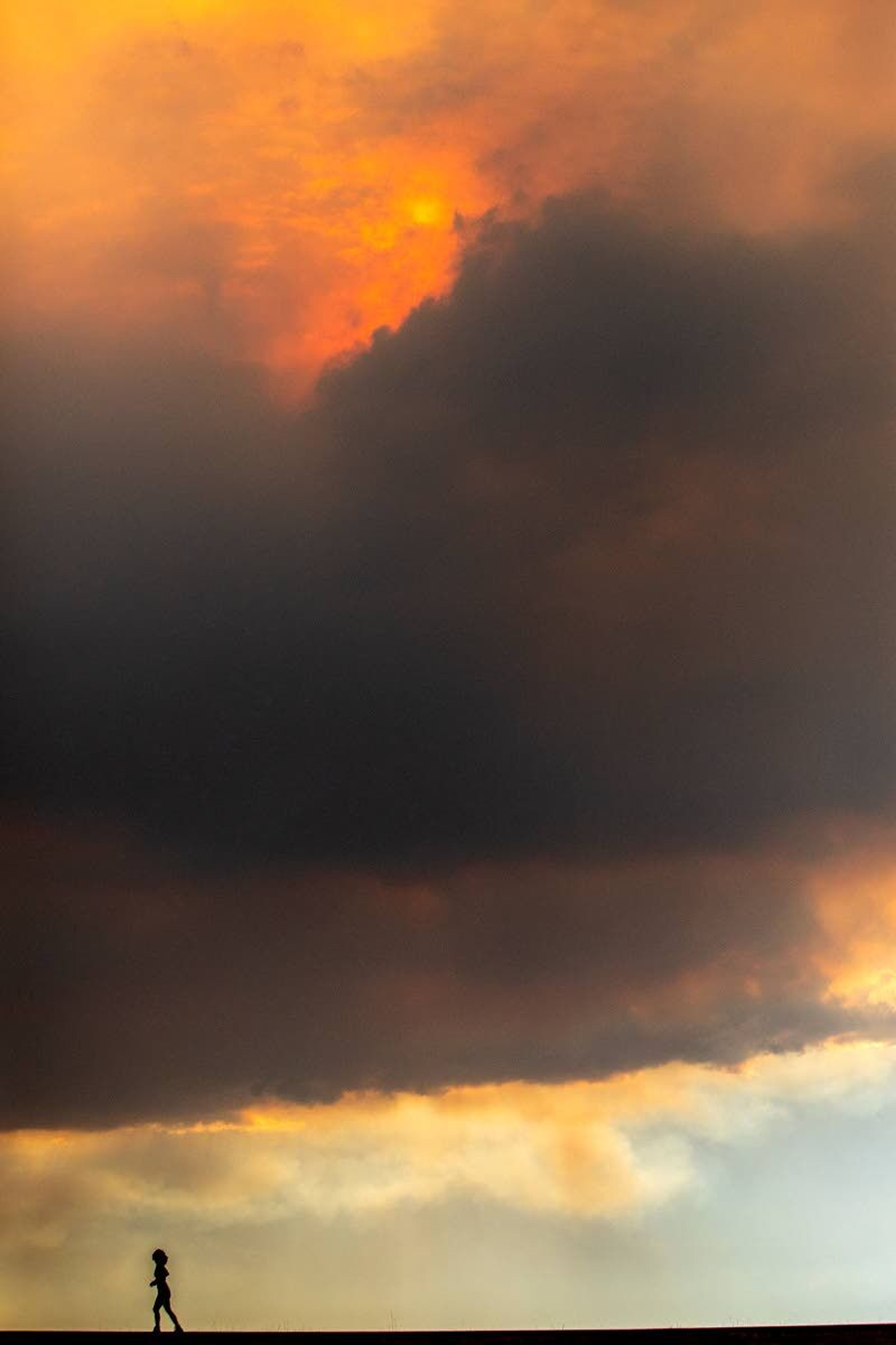 A woman backwards roller-skates down the Lewiston Levee Parkway Trail under heavy smoke moving over the valley on Saturday evening.