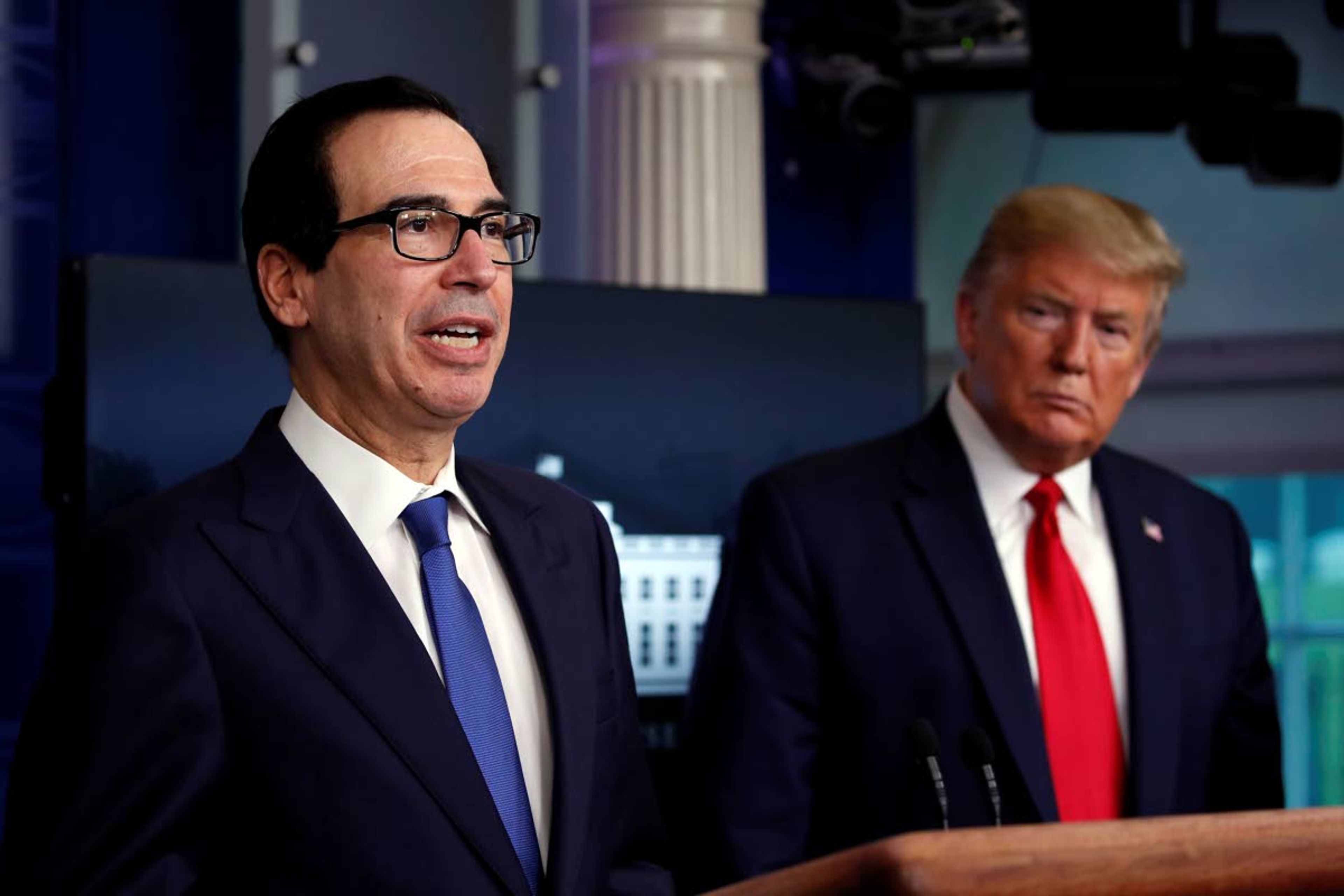 President Donald Trump listens as Treasury Secretary Steven Mnuchin speaks about the coronavirus last Monday in the James Brady Press Briefing Room at the White House in Washington. Associated Press