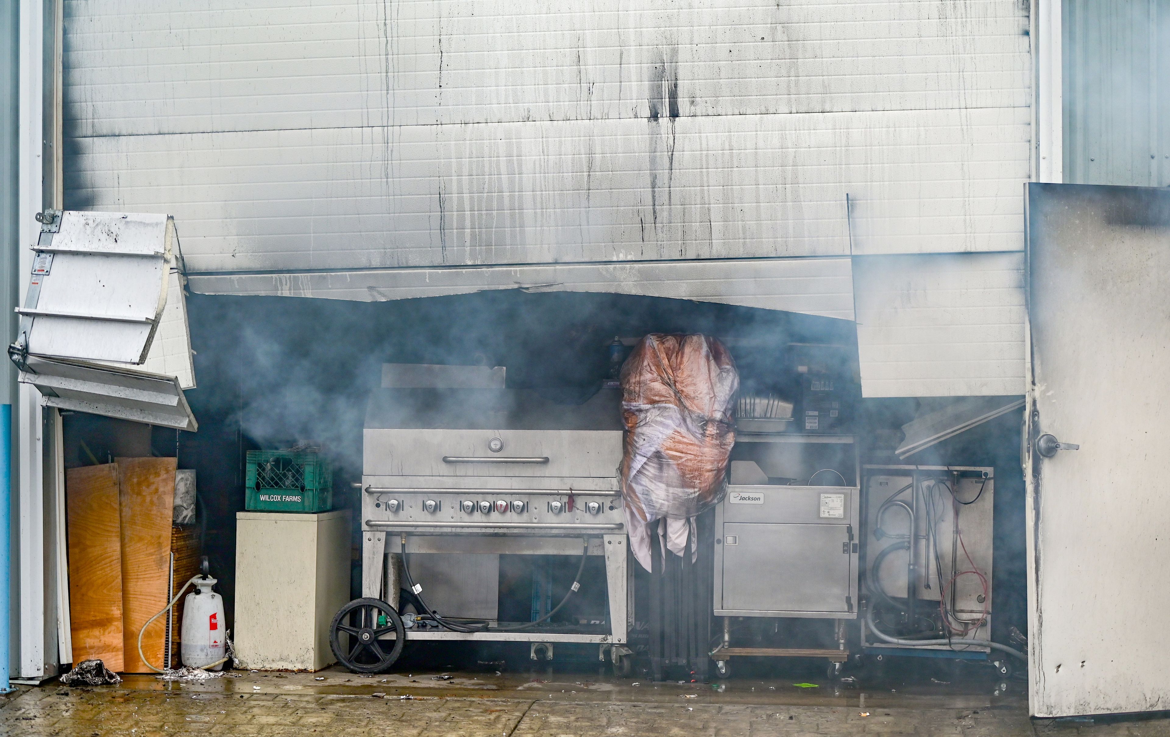 The garage doors to storage units were cut open by fire crews to gain access to a large fire at Express Storage along Moscow-Pullman Highway on Thursday.