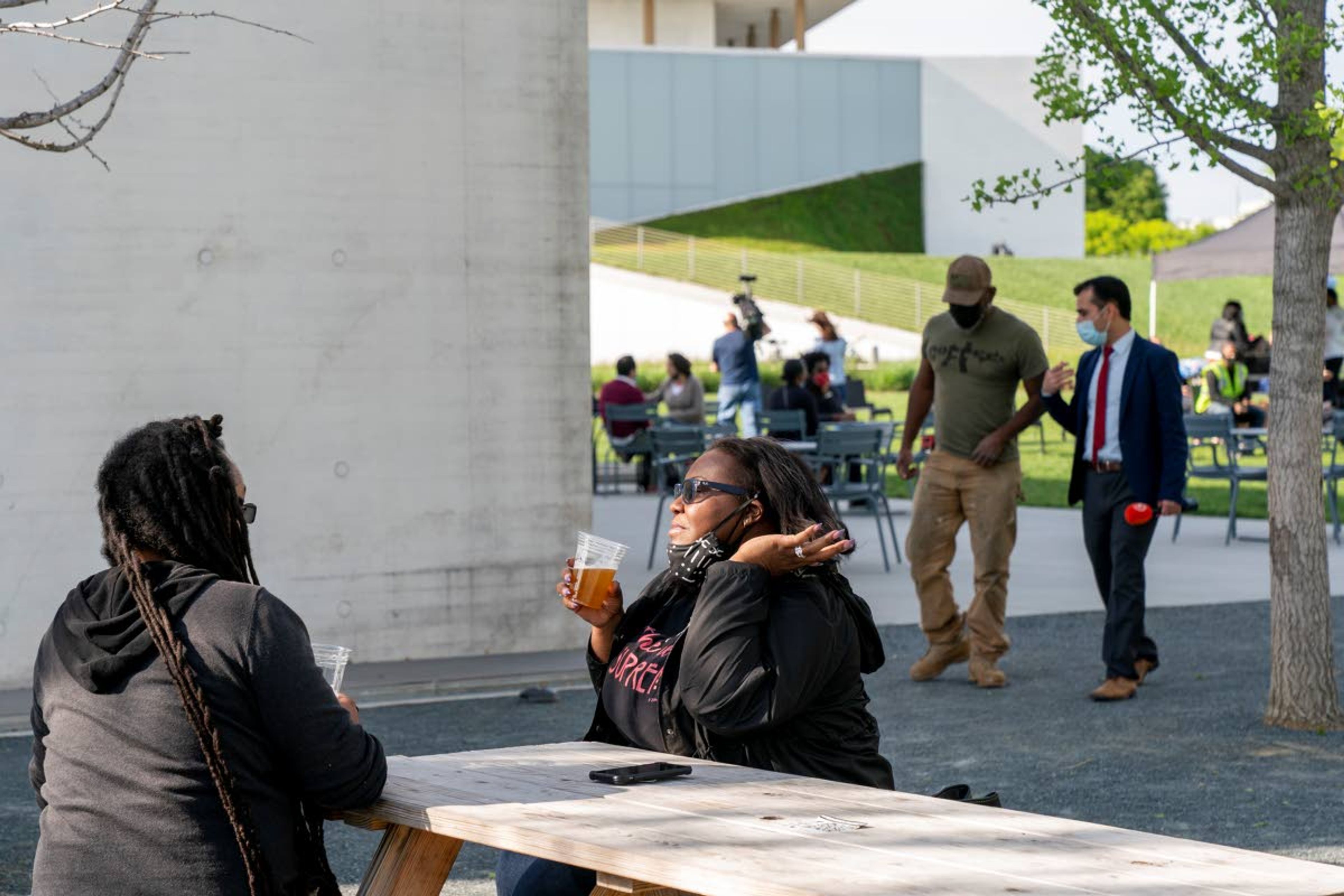 In this May 6, 2021 photo, Semajh Daniels, left, and Zora McCarthy, both of Hyattsville, Md., enjoy a complimentary beer after receiving the J & J COVID-19 vaccine, at The REACH at the Kennedy Center in Washington. Free beer is the latest White House-backed incentive for Americans to get vaccinated for COVID-19. President Joe Biden is expected to announce a “month of action” on Wednesday to get more shots into arms before the July 4 holiday. (AP Photo/Jacquelyn Martin)