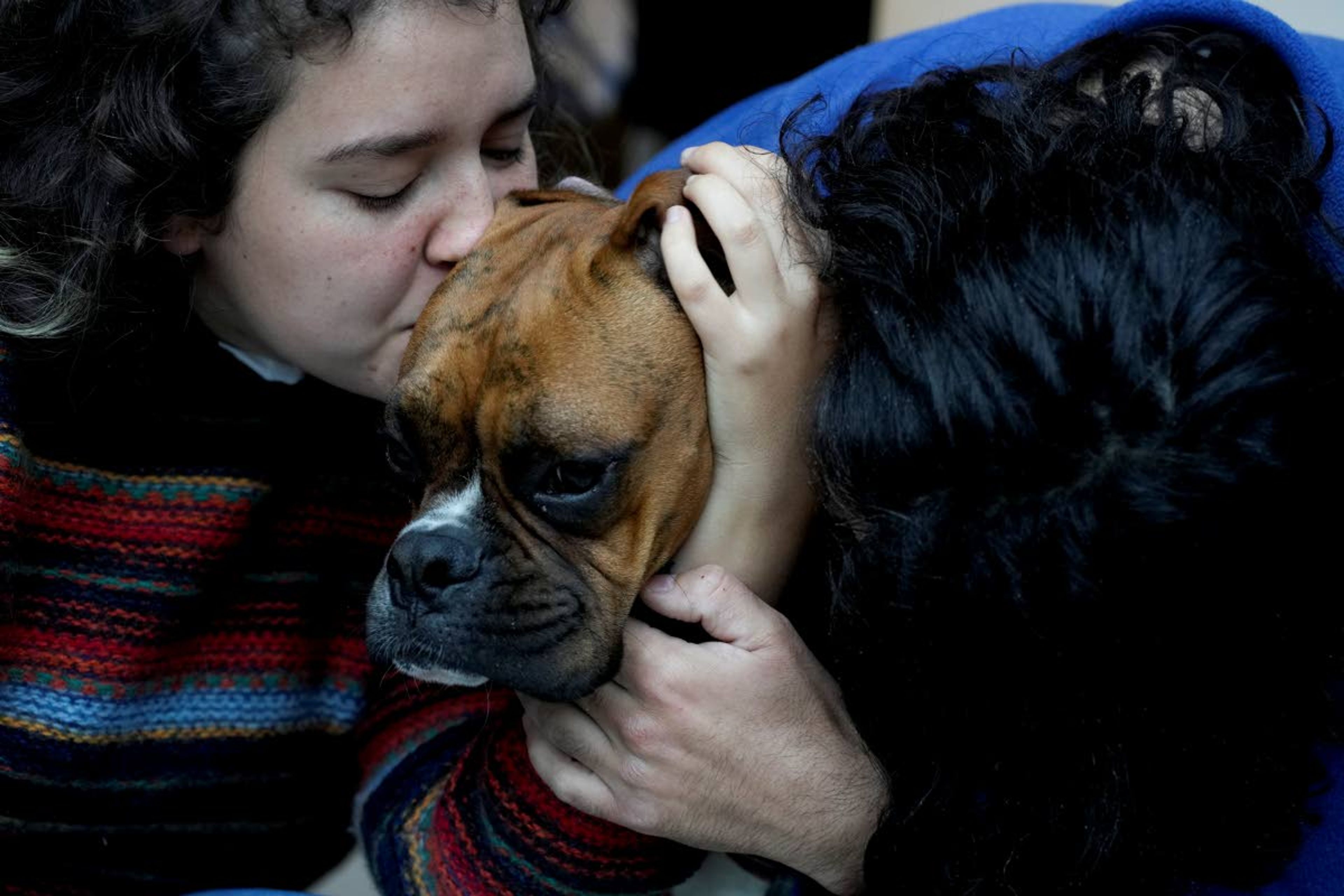 Agustina Ancales and her partner Pablo Vazquez pose for a photo with their dog Sigmoide in Lomas de Zamora, Argentina, Wednesday, Sept. 8, 2021. Ancales' mother got the dog for the couple as a gift after Vazquez was diagnosed with cancer during the COVID-19 lockdown to try to cheer them up. (AP Photo/Natacha Pisarenko)