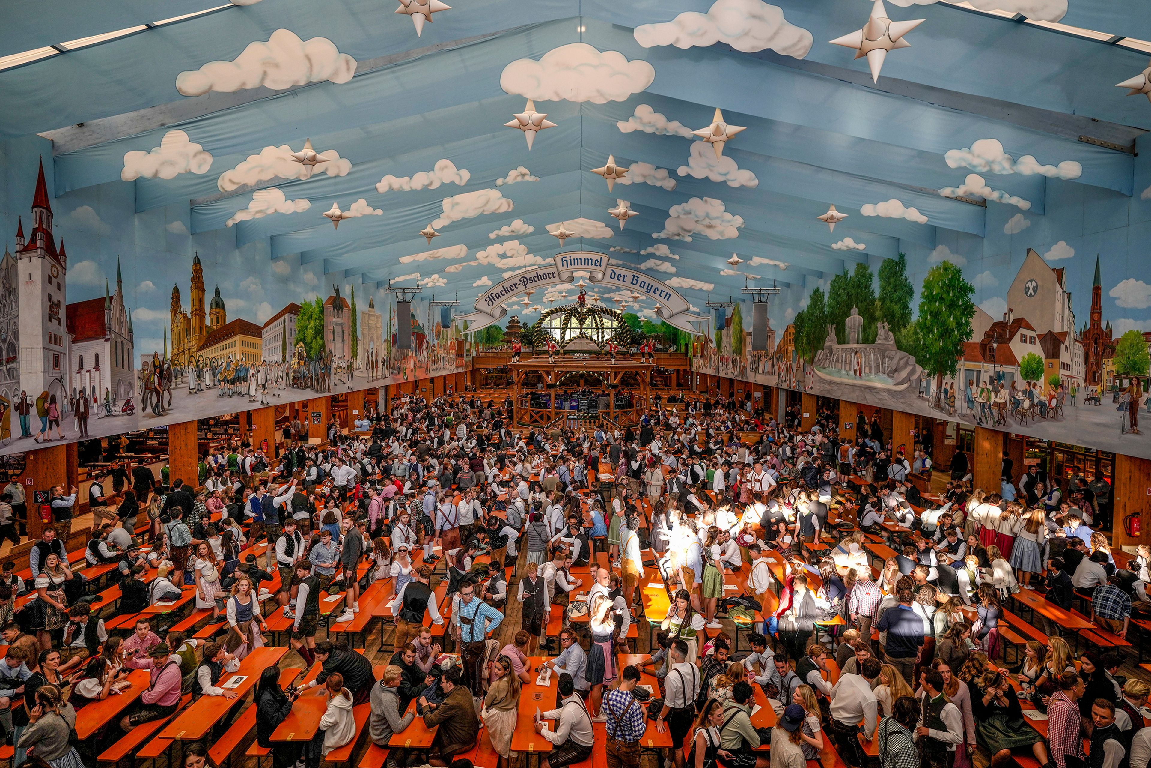 Visitors wait in the tent of the Hacker-Pschorr brewery, at the the start of the 189th 'Oktoberfest' beer festival in Munich, Germany, Saturday, Sept. 21, 2024. (AP Photo/Matthias Schrader),