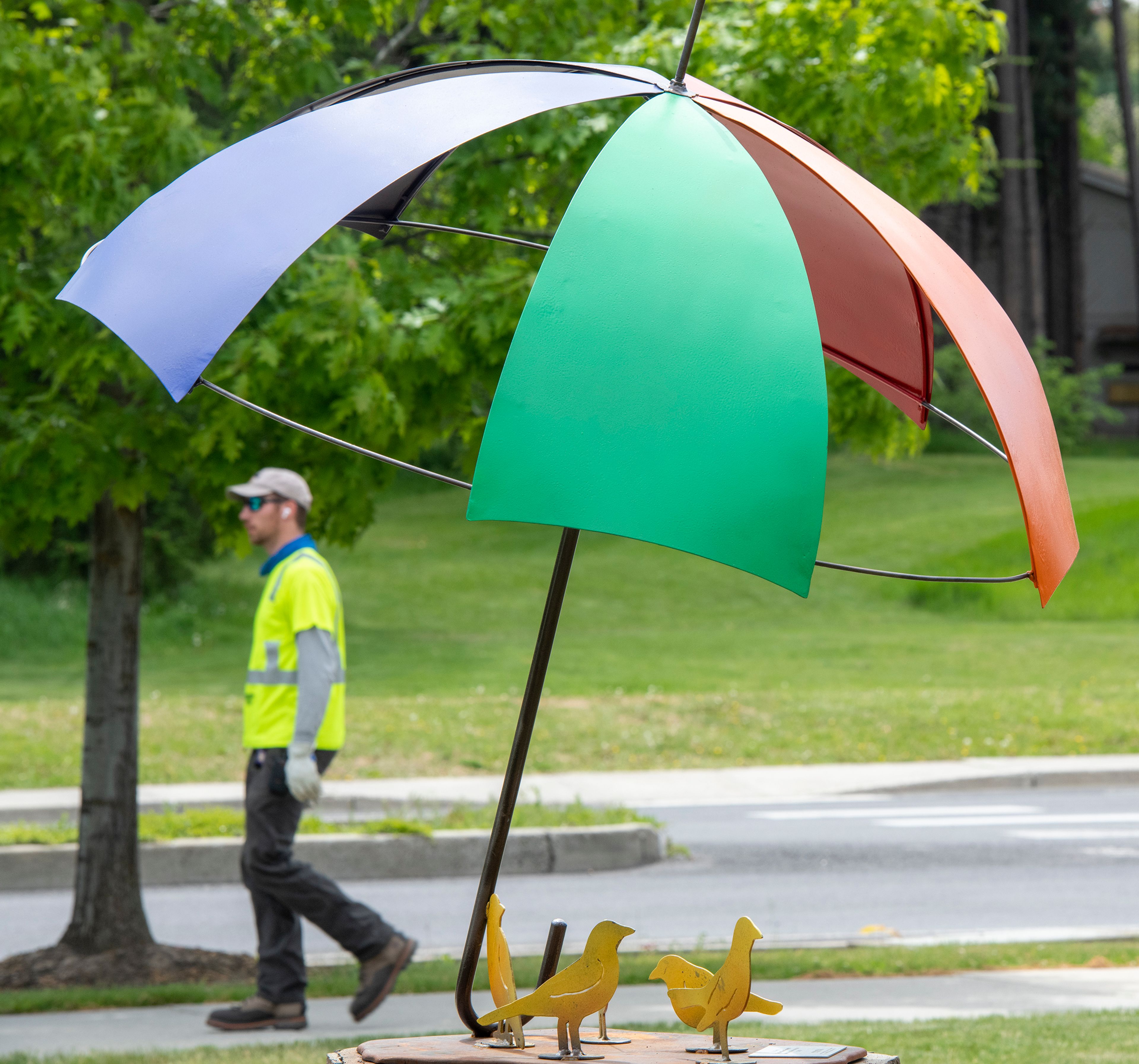 A pedestrian moves behind artwork titled “The Sun Shines Through It” by Jill Kyong displayed in the Sculpture Garden outside of Moscow’s Intermodal Transit Center.