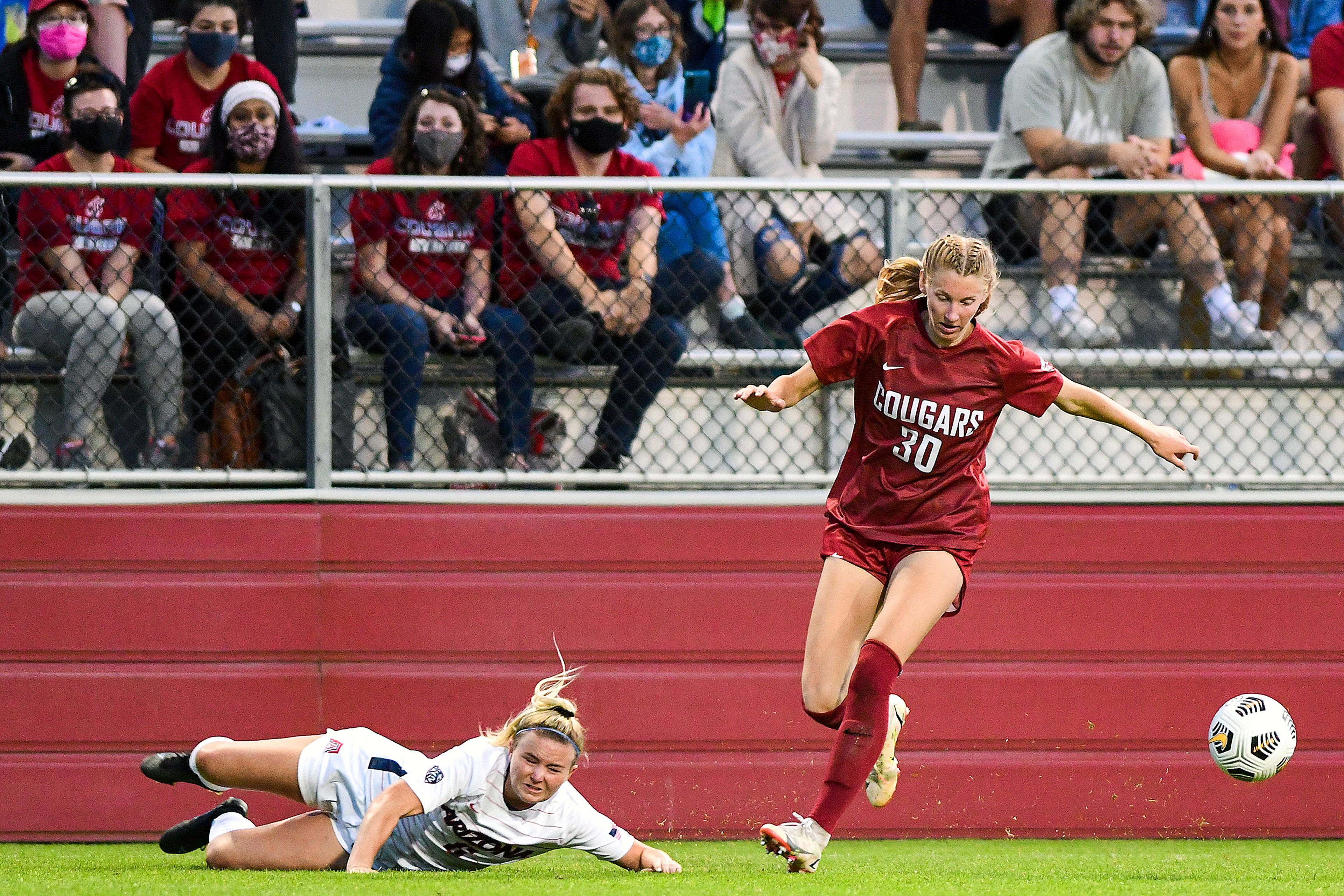 Washington State’s Sydney Studer (30) dribbles past a sliding Arizona defender during the second half of a Pac-12 game on Friday evening at the Lower Soccer Field in Pullman.