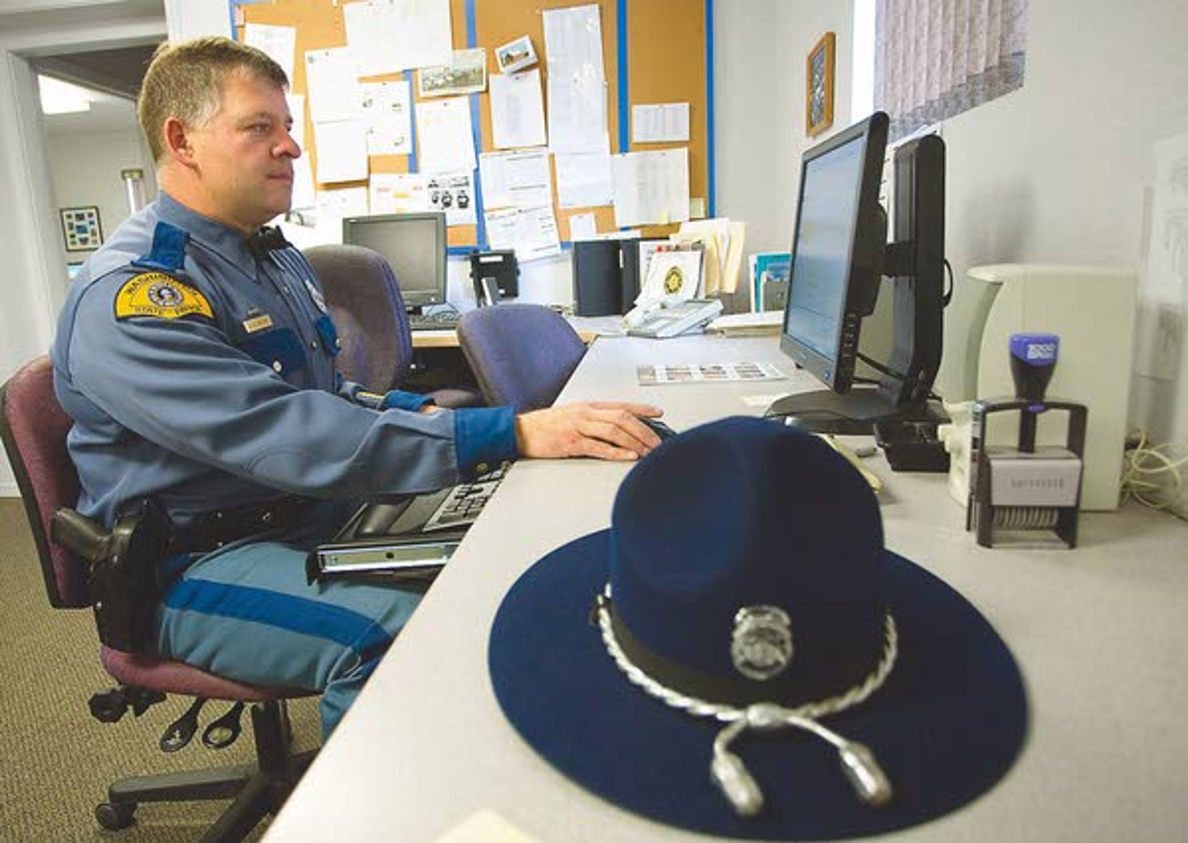 Washington State Patrol Trooper James Retzer works in his office in Colfax on Wednesday.