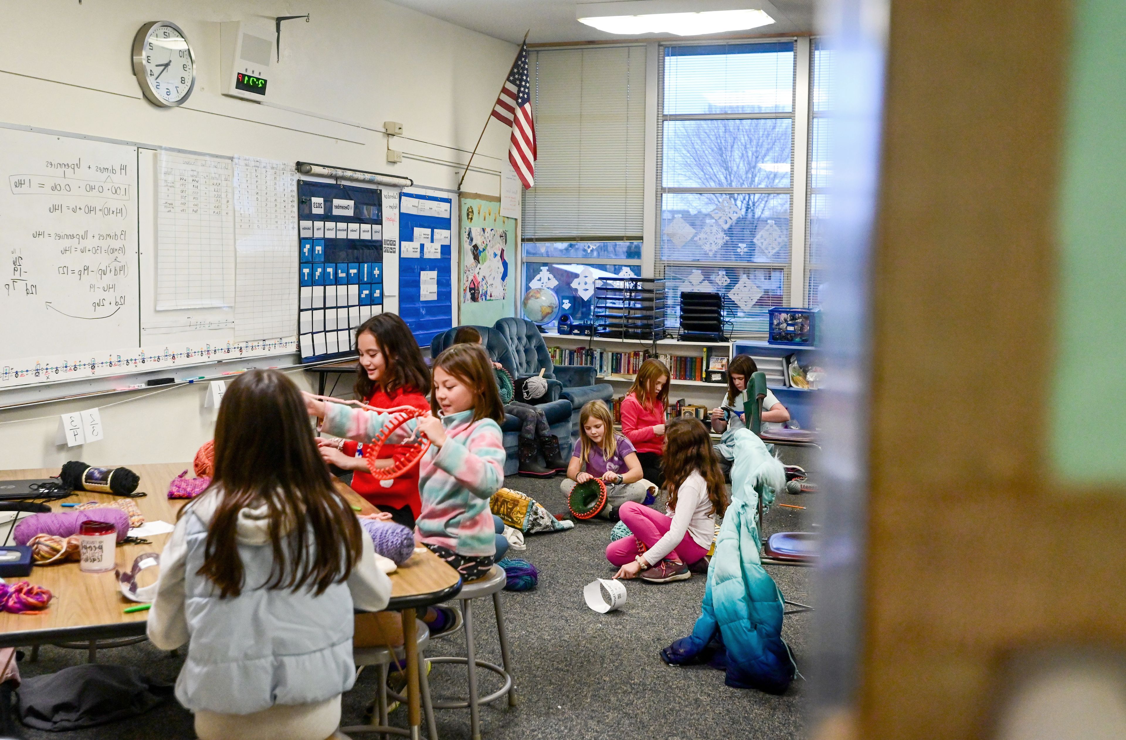 Members of Lena Whitmore Elementary School’s knitting club work on hats in the classroom of fourth grade teacher Linsey Lee after school in Moscow on Monday.