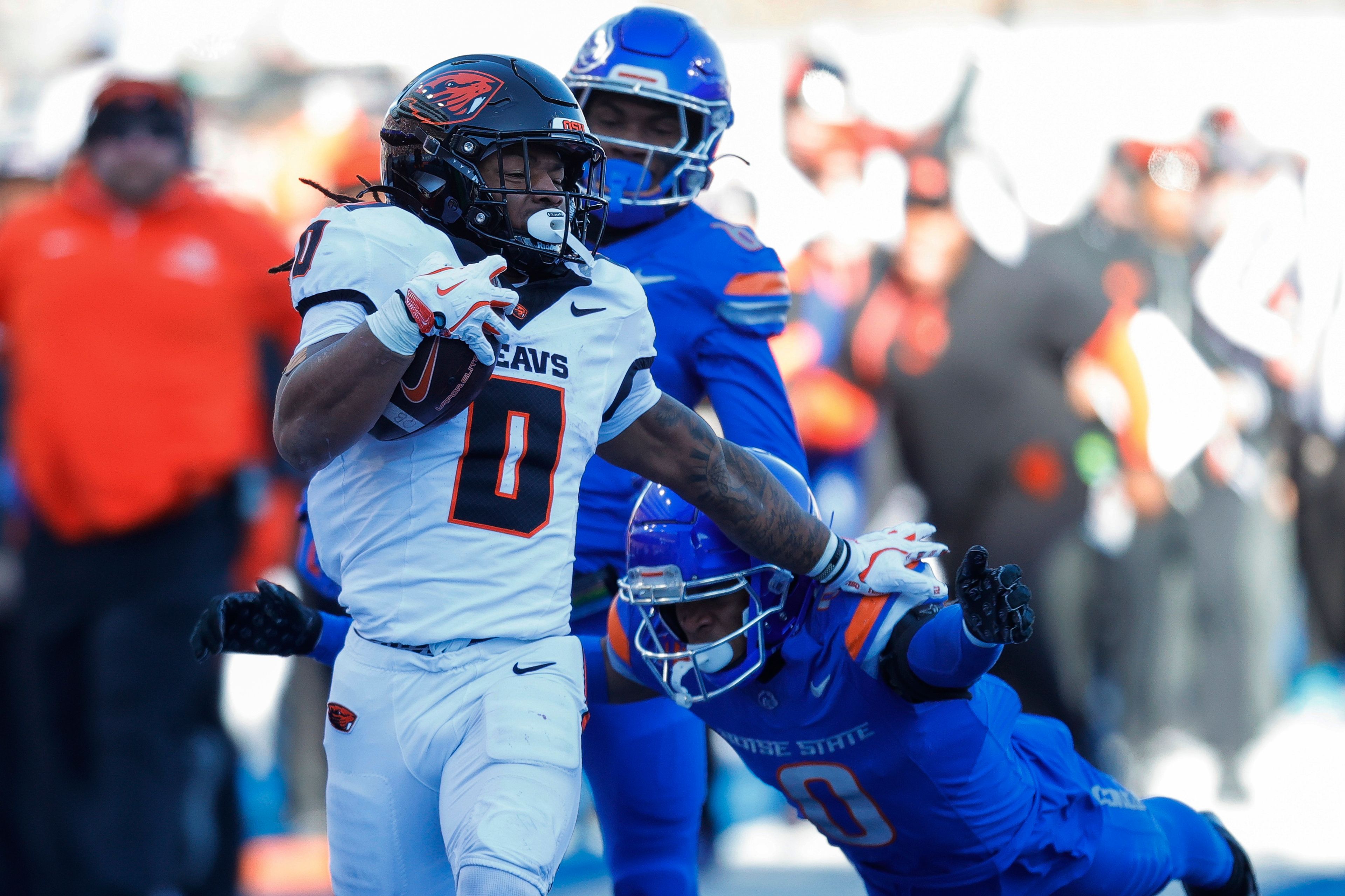 Oregon State running back Anthony Hankerson (0) holds of the diving tackle attempt by Boise State safety Ty Benefield (0) on a 83 yard touchdown run in the first half of an NCAA college football game, Friday, Nov. 29, 2024, in Boise, Idaho. (AP Photo/Steve Conner)