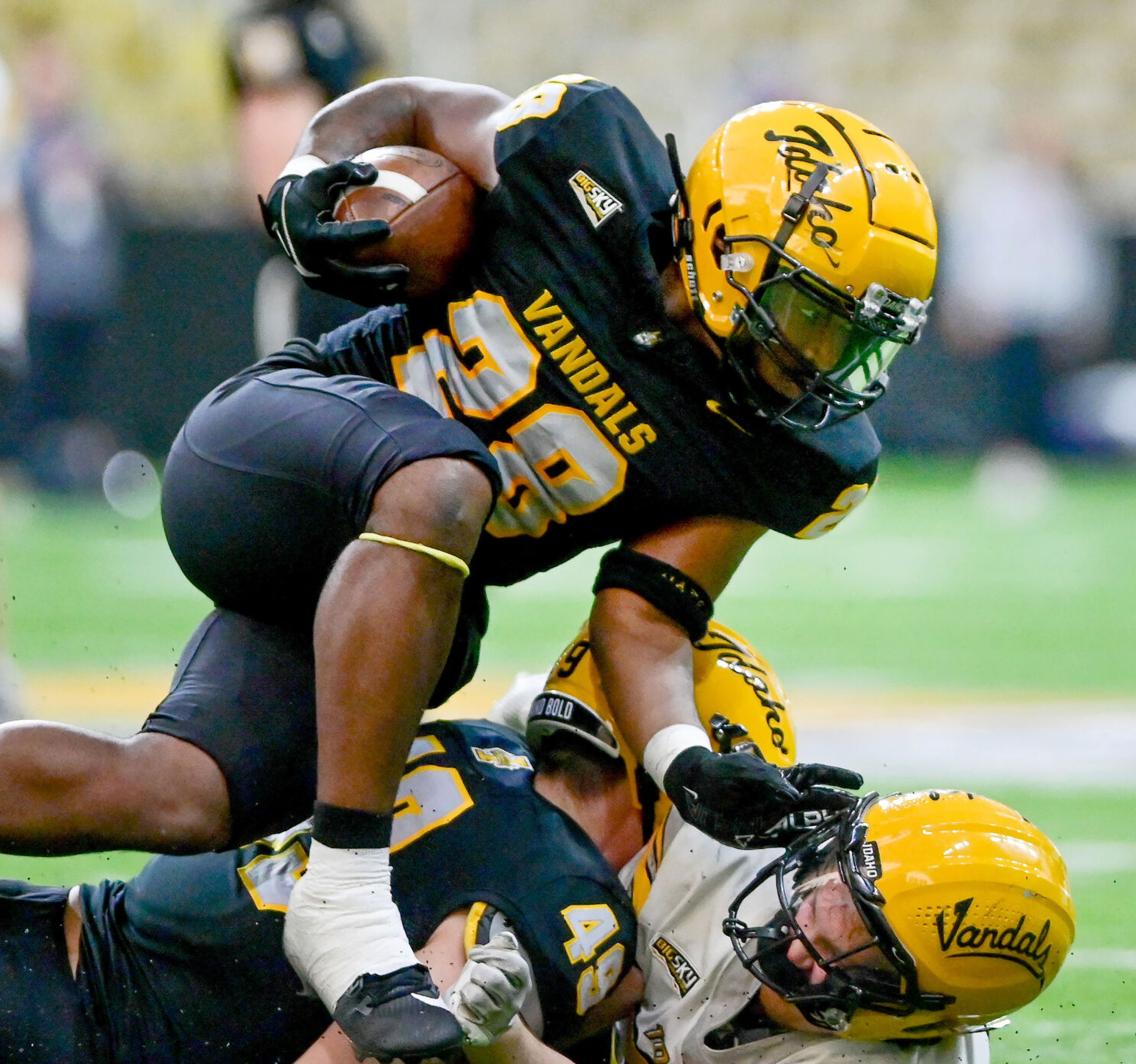 Vandals running back Nate Thomas (28) jumps over teammates before being tackled during the annual spring game Friday at the P1FCU Kibbie Dome in Moscow.