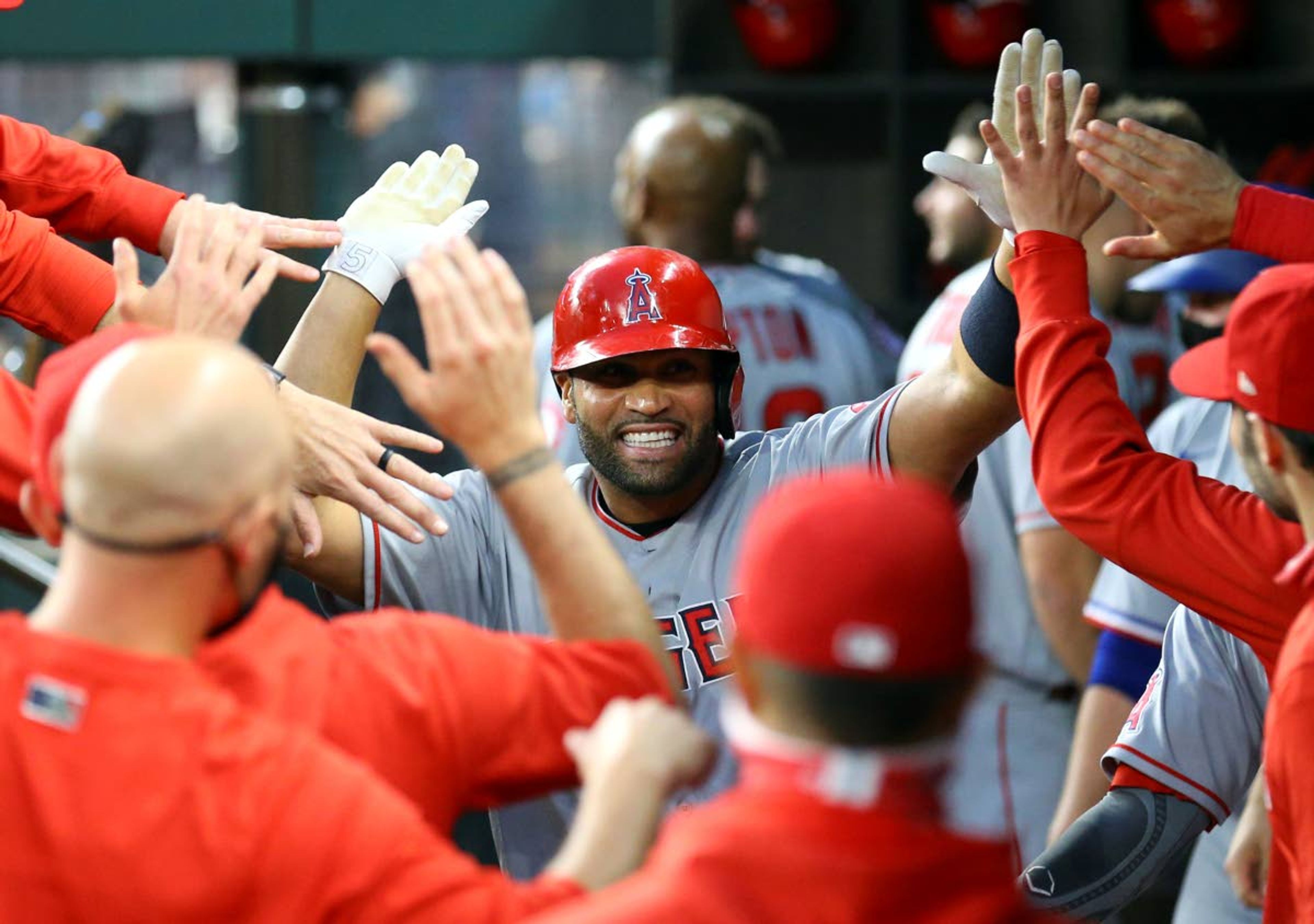 FILE - Los Angeles Angels first baseman Albert Pujols (5) is greeted in the dugout after a solo home run against the Texas Rangers in the third inning during a baseball game in Arlington, Texas, in this Monday, April 26, 2021, file photo. Pujols has been designated for assignment by the Los Angeles Angels, abruptly ending the 41-year-old superstar slugger's decade with his second major league team. The Angels announced the move Thursday, May 6, 2021, a day after Pujols wasn't in their lineup for their fourth consecutive loss. (AP Photo/Richard W. Rodriguez, File)