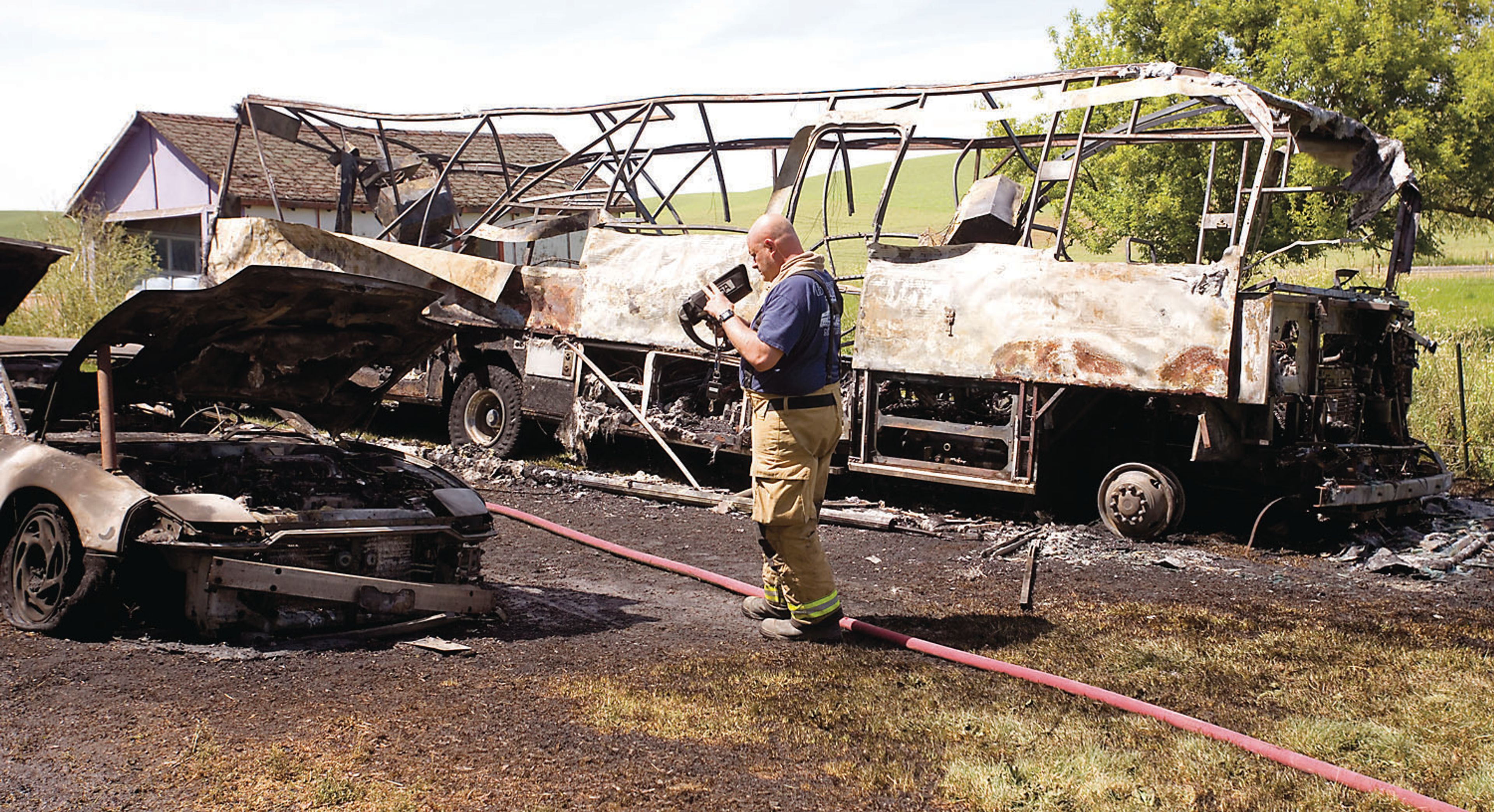 Palouse Fire Chief Mike Baggott uses a heat detector to ensure there are no hot spots after a motorhome and two cars burned outside a home at the intersection of state Route 272 and Swanson Road on Wednesday west of Palouse. Firefighters from Whitman County Fire Districts 4, 11 and 12 responded to the fire. Investigators from the Pullman Dire Department were called in to assist, as the cause of the fire appears to be suspicious in nature, Fire District 12 Chief Lester Erwin said. A fire, also of unknown causes, destroyed an abandoned trailer near Potlatch on Sunday.