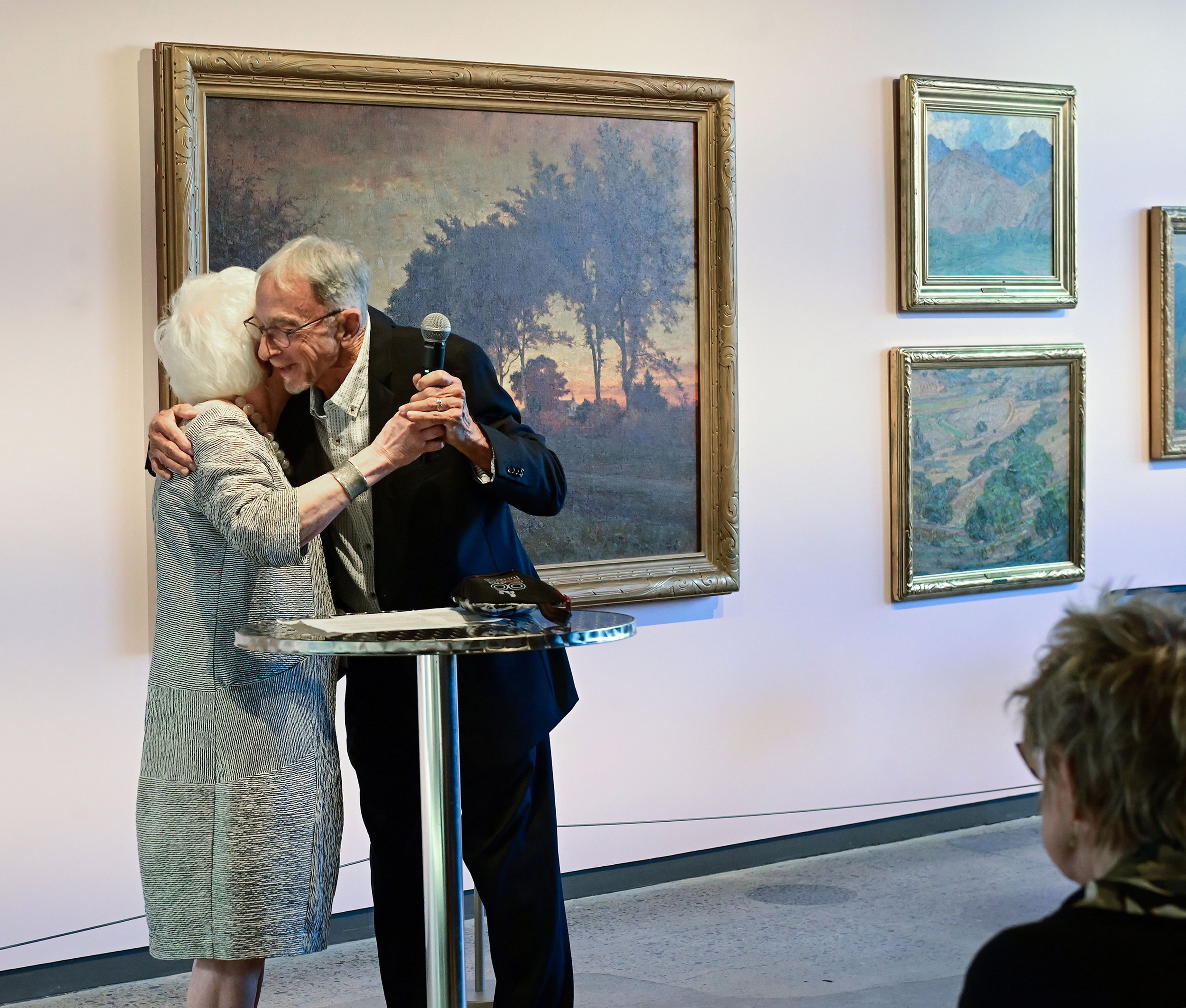 Former Washington State University art museum directors Patricia Watkinson, left, and Chris Bruce embrace between speeches at the museums 50 year anniversary reception and book release Thursday in Pullman.,