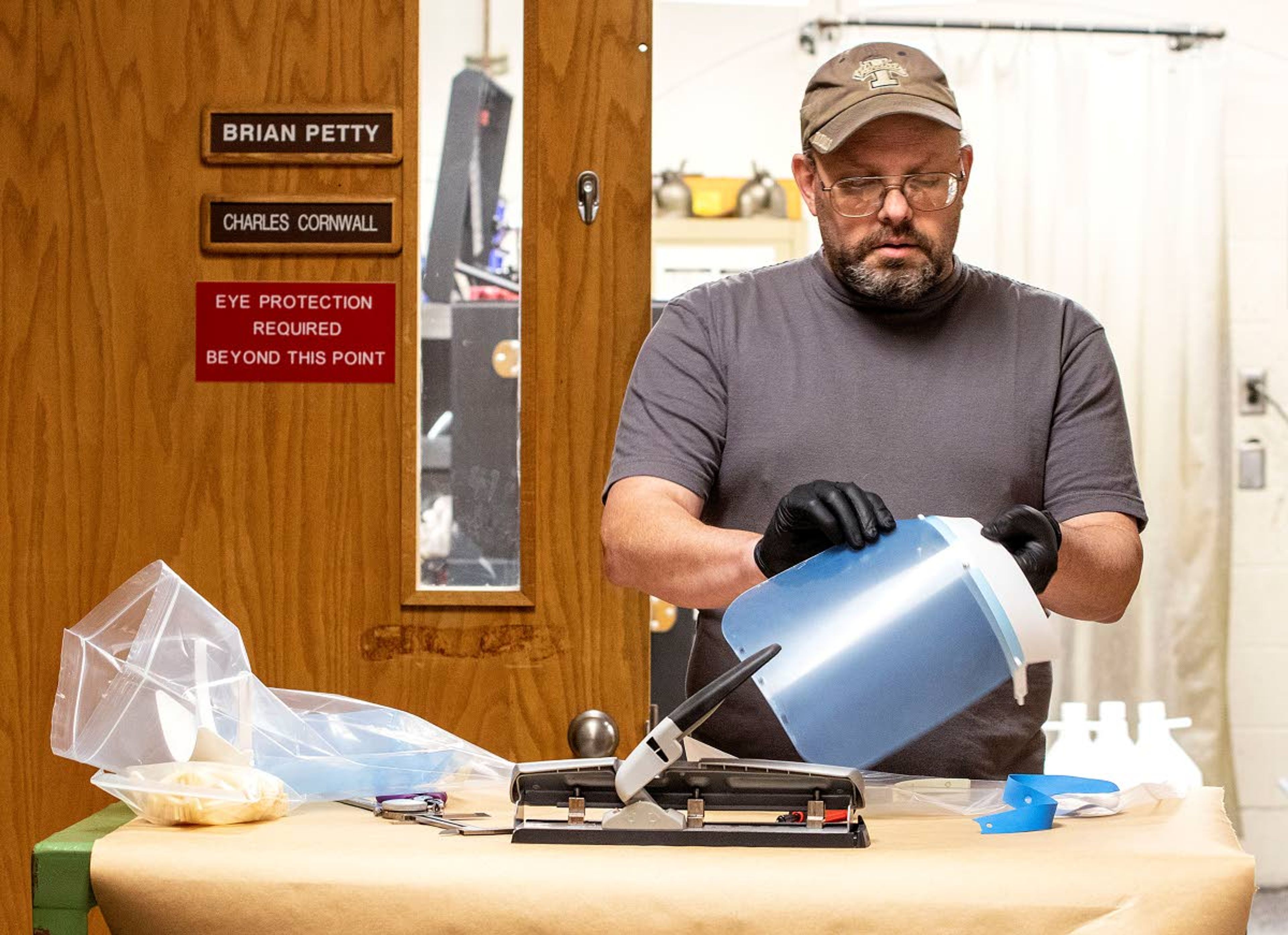 Geoff Crimmins/Daily NewsABOVE: Charles Cornwall assembles a plastic face shield after making the parts Thursday at the University of Idaho engineering laboratory in Moscow. The face shields are being made for medical providers in the area. The head band is 3D printed, while the plastic sheet is cut with a laser cutter. TOP: A 3D printer creates the head band for a face shield Thursday. The face shields are being made for potential use for medical providers.