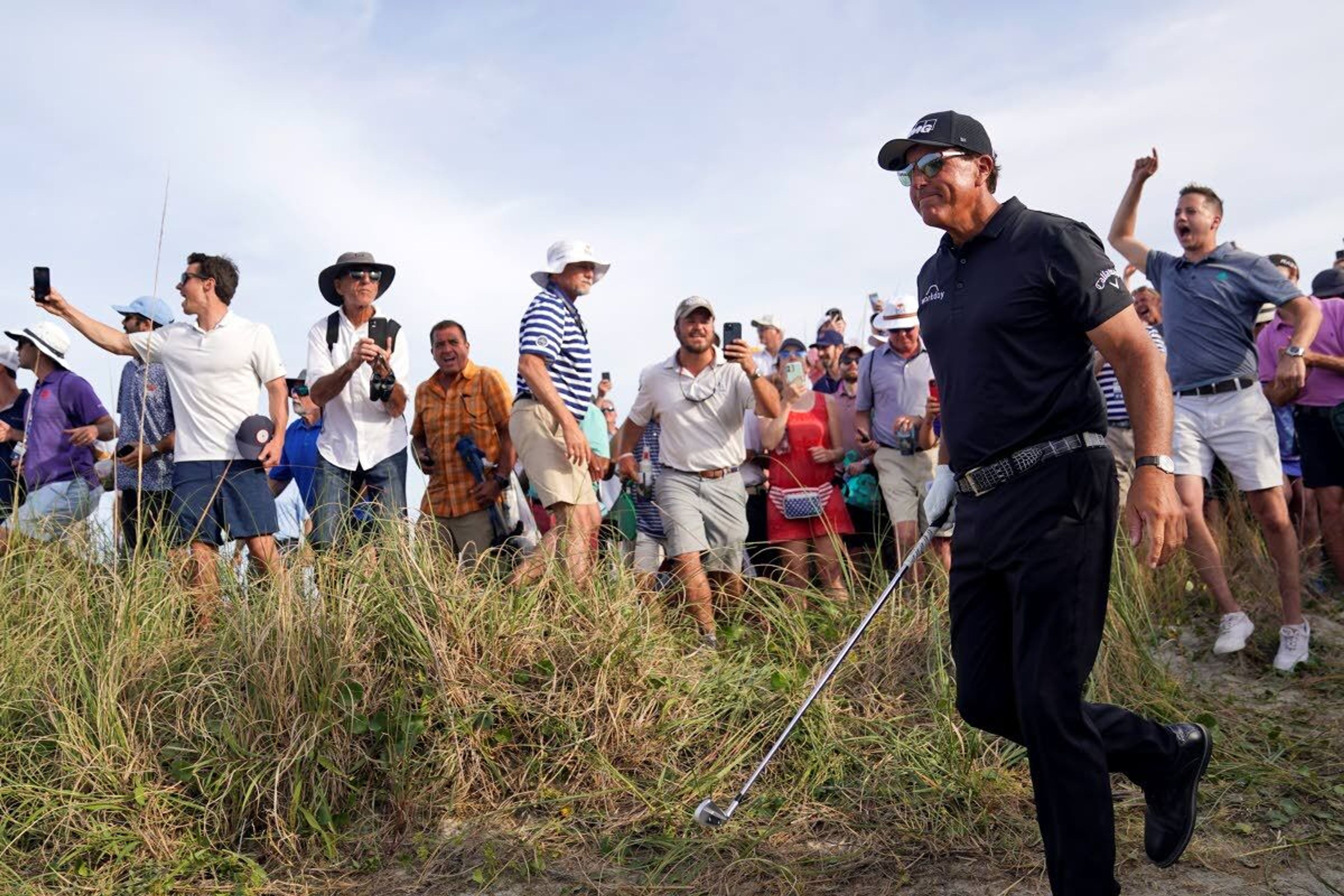 Fans cheer after Phil Mickelson hit his second shot on the 16th hole from the rough during the third round at the PGA Championship golf tournament on the Ocean Course, Saturday, May 22, 2021, in Kiawah Island, S.C. (AP Photo/David J. Phillip)