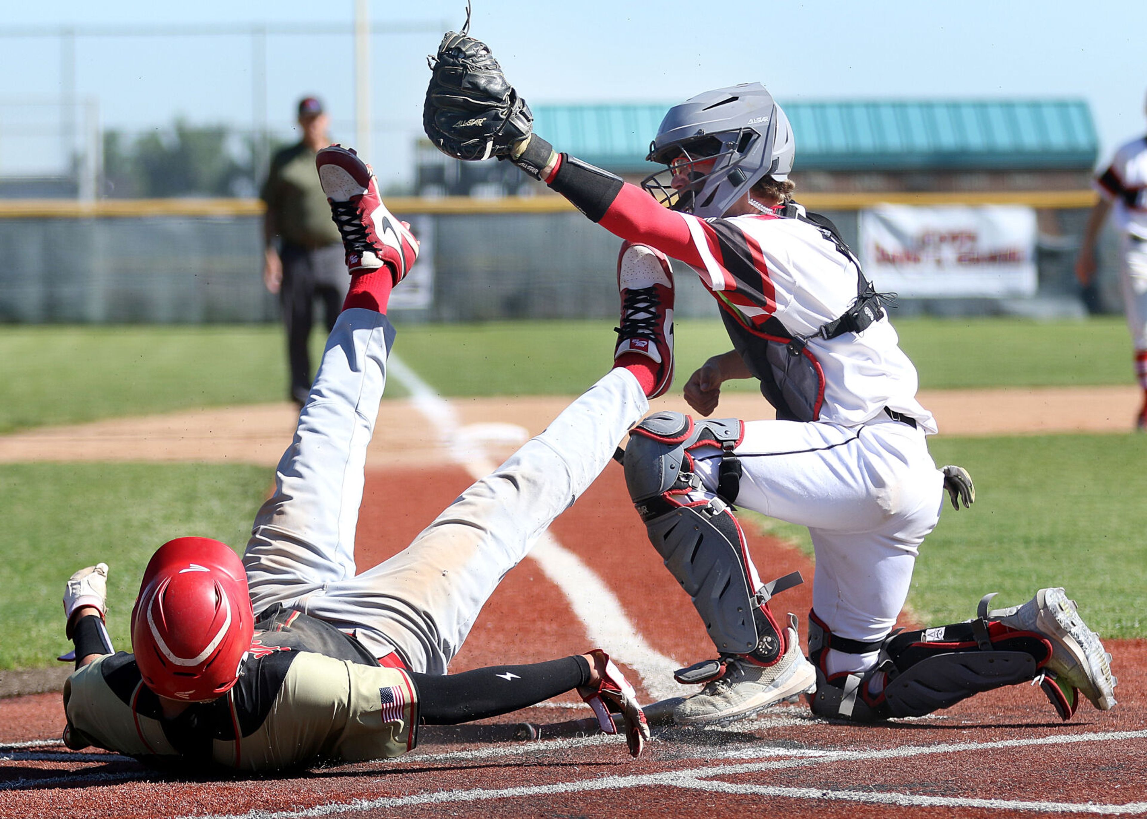 Moscow catcher Tyson Izzo, right, raises his glove after tagging a Minico runner at home plate in an Idaho Class 4A state tournament game Thursday, May 16, 2024, at Vallivue High School in Caldwell.