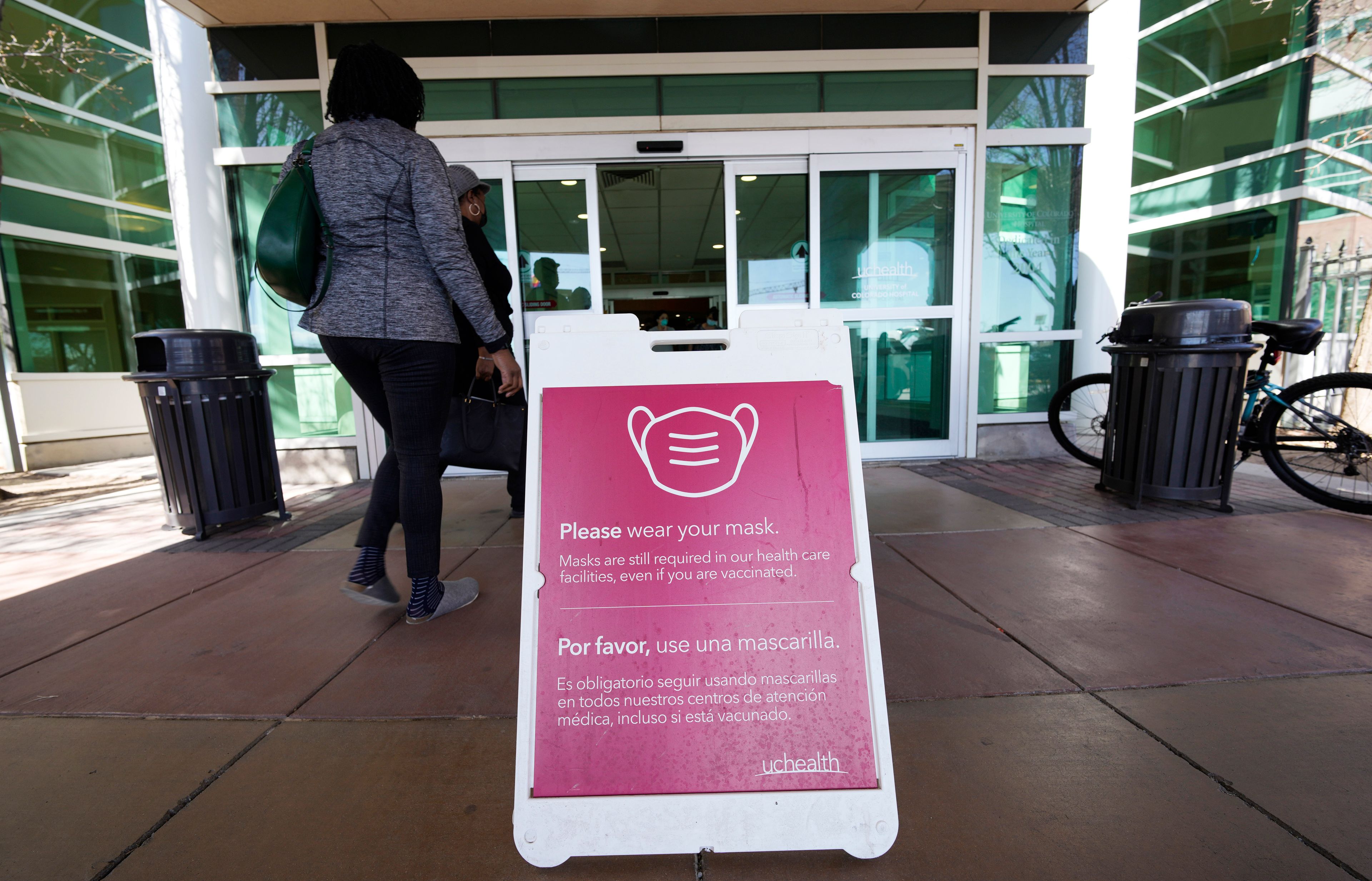 FILE - A sign advising visitors to don face coverings stands outside the main entrance to UCHealth University of Colorado hospital Friday, April 1, 2022, in Aurora, Colo. An extra-contagious version of the omicron coronavirus variant has taken over the world. The variant scientists call BA.2 is now dominant in at least 68 countries, including the U.S. The World Health Organization says it makes up about 94% of sequenced omicron cases submitted in the most recent week to an international database. (AP Photo/David Zalubowski, File)