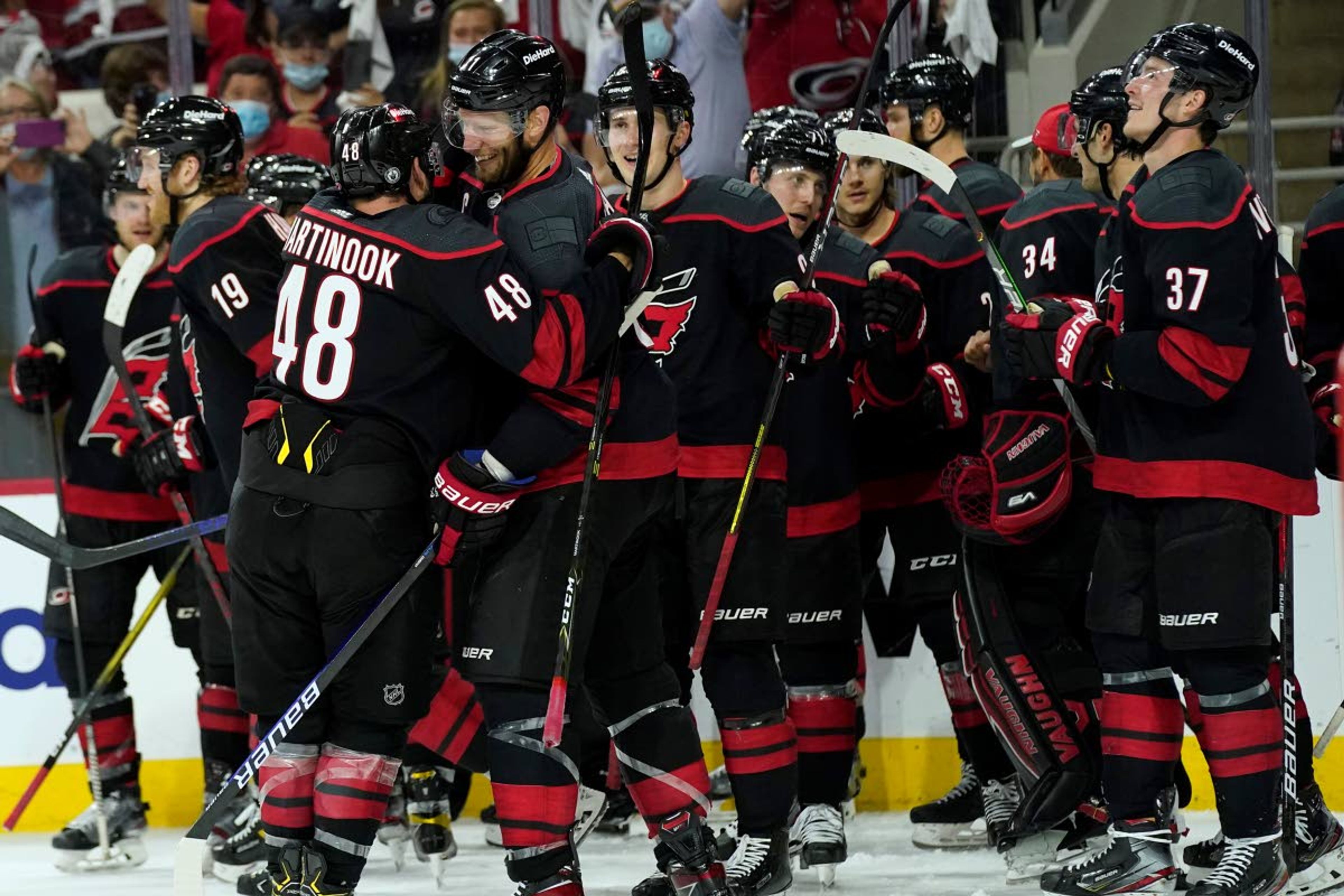 Carolina Hurricanes left wing Jordan Martinook (48) hugs center Jordan Staal (11) after Staal scored during overtime in Game 5 of an NHL hockey Stanley Cup first-round playoff series against the Nashville Predators in Raleigh, N.C., Tuesday, May 25, 2021. (AP Photo/Gerry Broome)