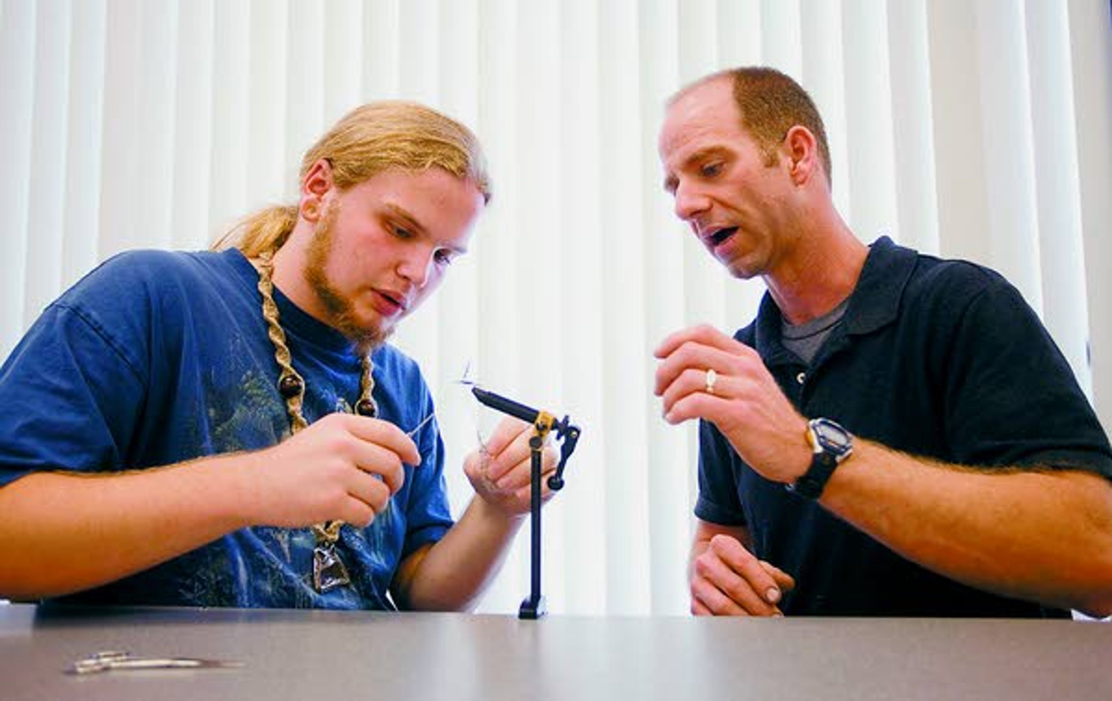 Teacher Matt Pollard, right, answers a question George Hiatt had while tying an adimus fly Wednesday during an ecology class at Paradise Creek Regional High School in Moscow.