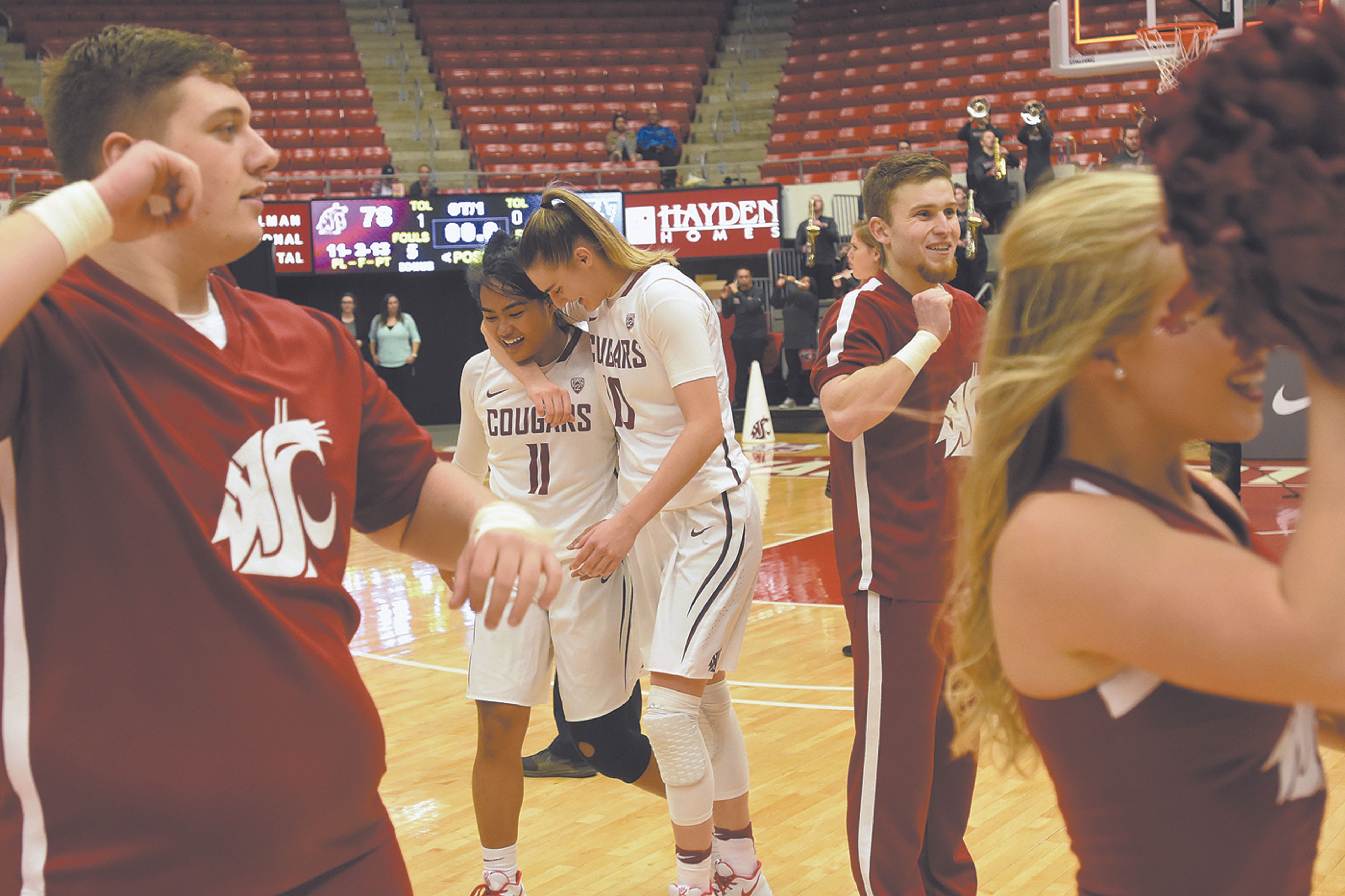 Washington State guards Chanelle Molina (11) and Johanna Muzet (10) celebrate after beating Washington, 78-75, in overtime of a PAC-12 Conference game Wednesday in Pullman, Wash.