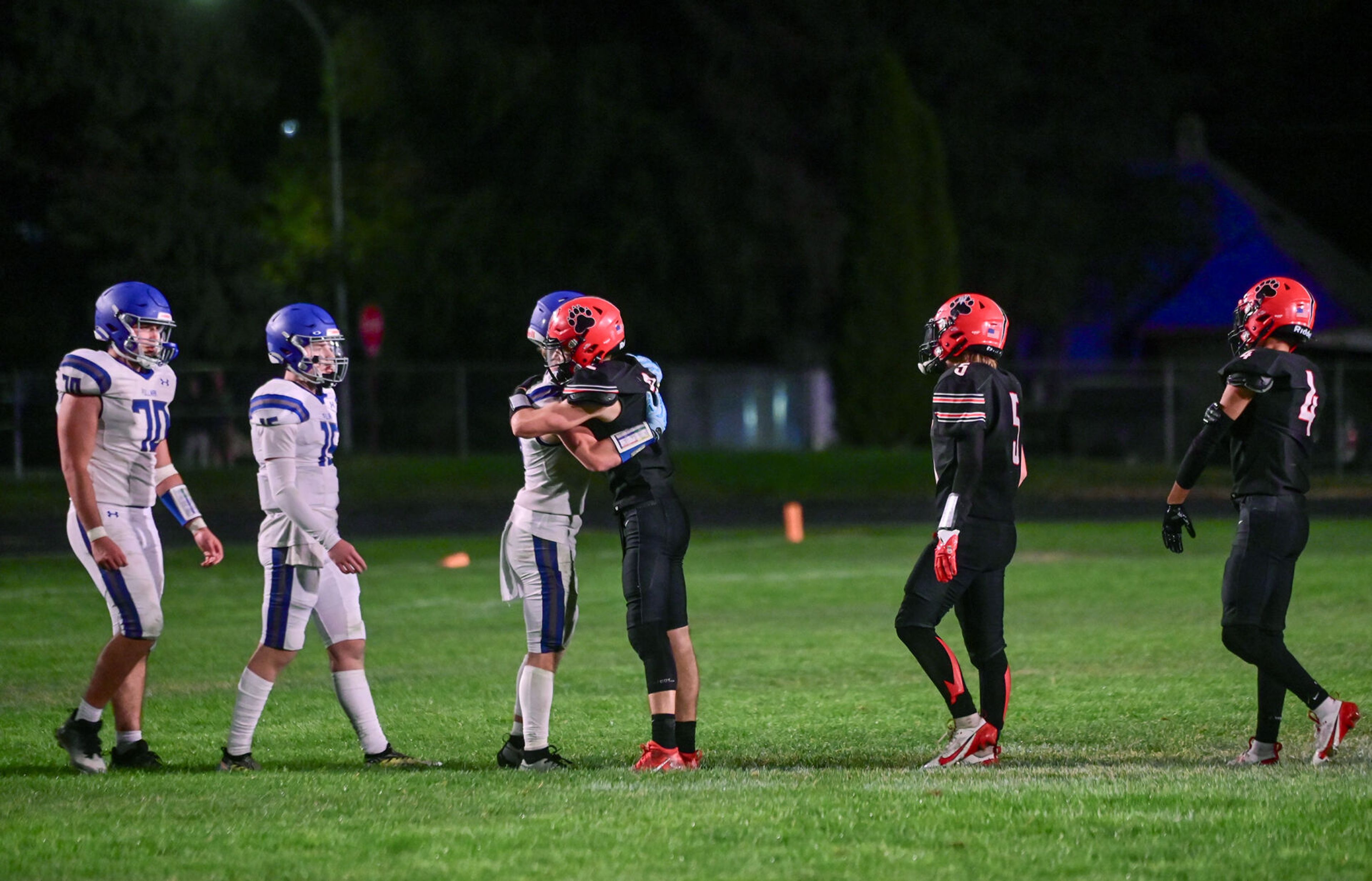 Pullman running back Brady Coulter and Moscow wide receiver Butch Kiblen embrace after the game Friday in Moscow.