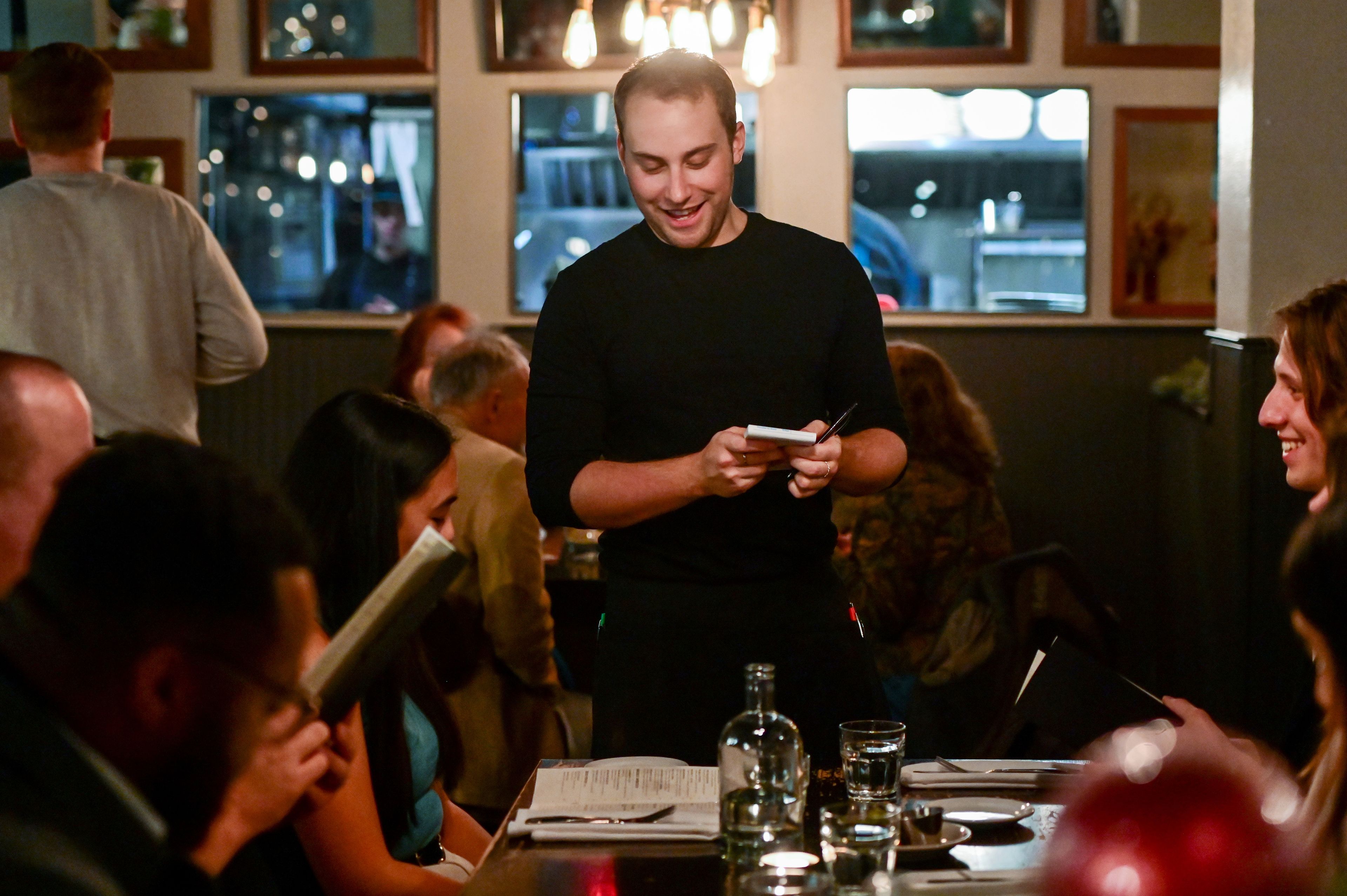 Server Joshua Bianco, center, greets a table at The Black Cypress in Pullman on Tuesday, Nov. 14.