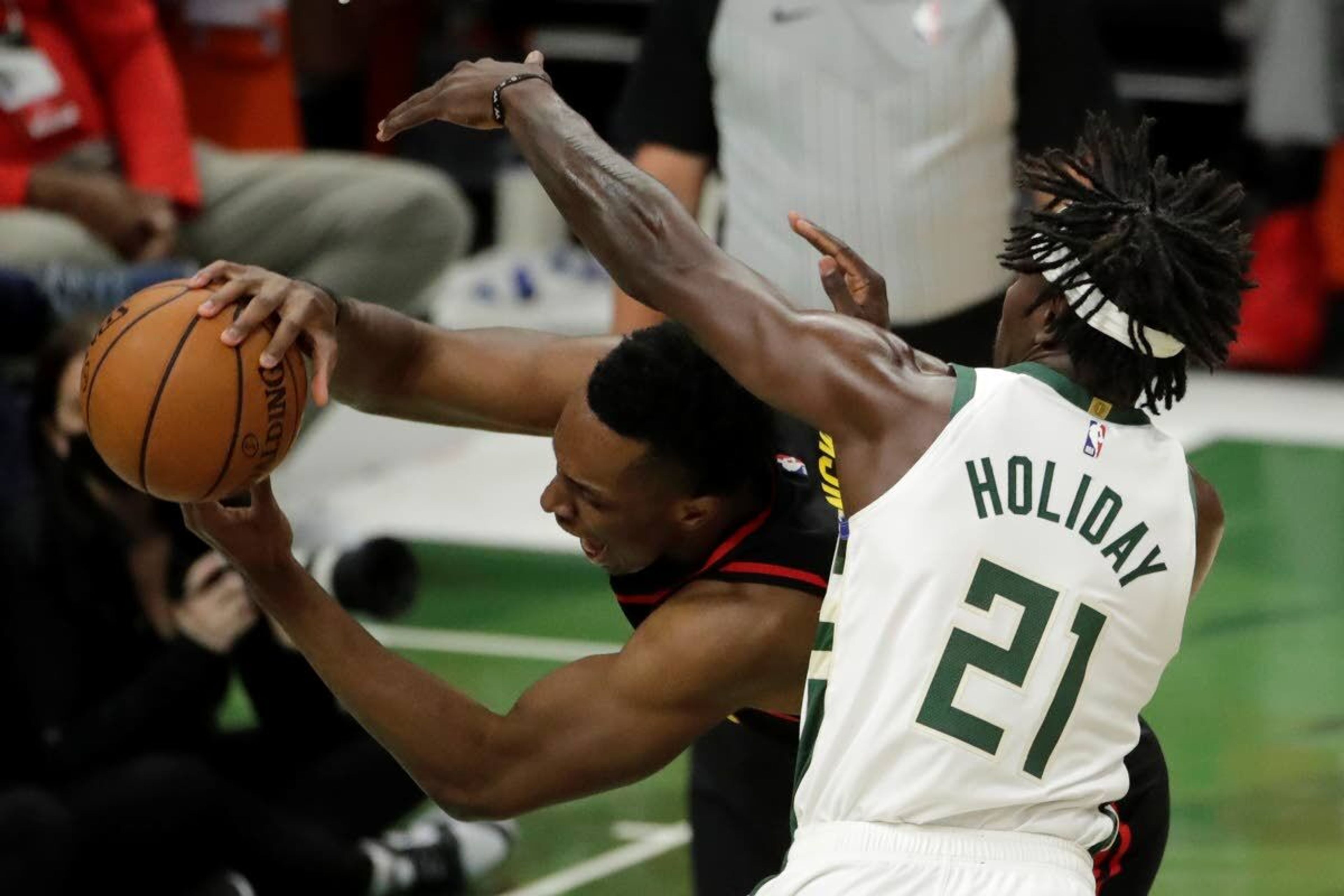 Milwaukee Bucks' Jrue Holiday, right, fouls Atlanta Hawks' Onyeka Okongwu, left, during the first half of Game 5 of the NBA Eastern Conference Finals Thursday, July 1, 2021, in Milwaukee. (AP Photo/Aaron Gash)