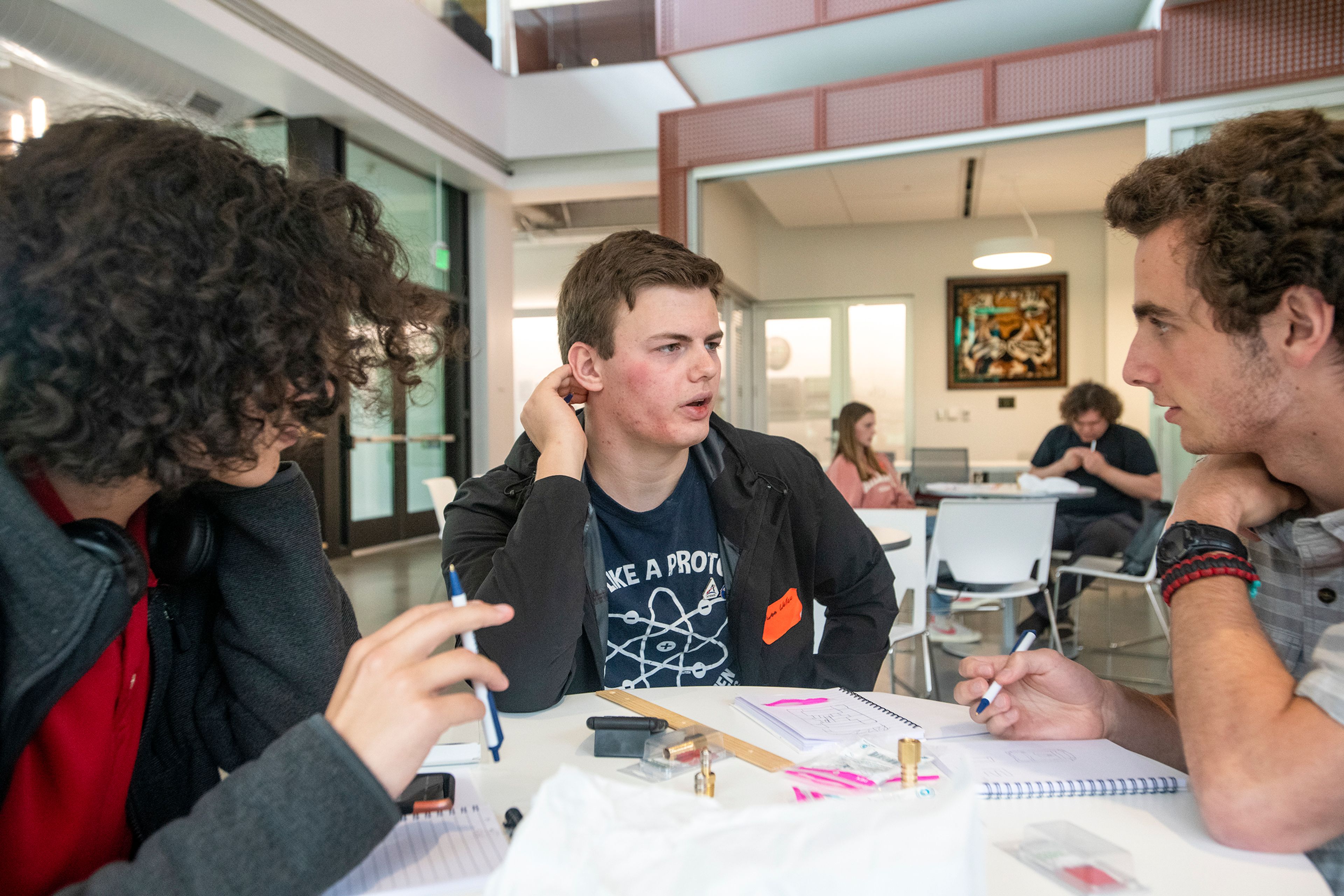 Xavier Borton-Garcia, of Lewiston, from left, Owen Wallace, of Moscow, and Kurt Robison, of Boise, discuss their plan to assemble an air-powered rocket during the Idaho Science and Aerospace Scholars capstone event Monday inside the atrium of the Integrated Research and Innovation Center on University of Idaho’s campus in Moscow.