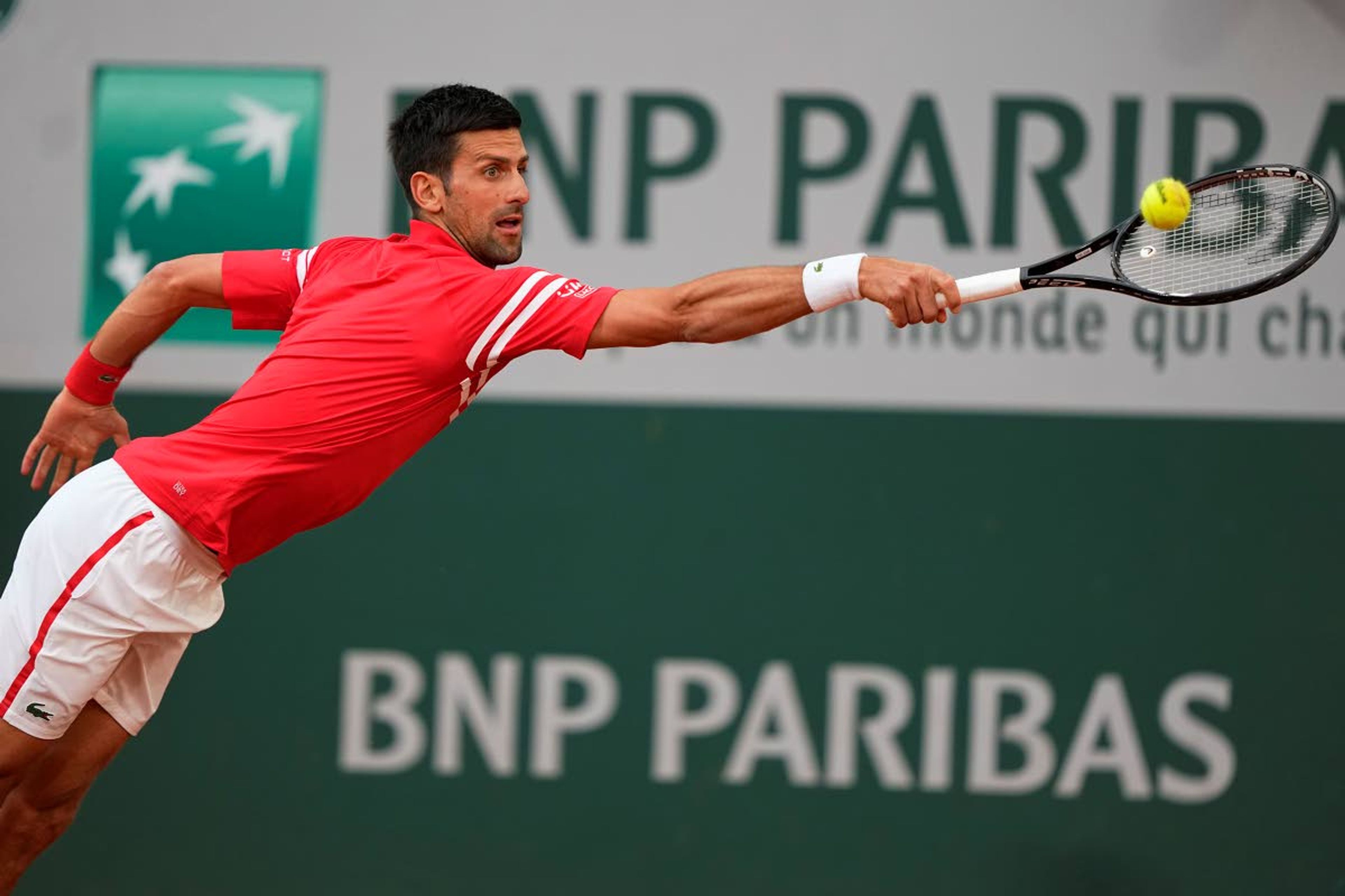 Serbia's Novak Djokovic stretches to return the ball to Italy's Matteo Berrettini during their quarterfinal match of the French Open tennis tournament at the Roland Garros stadium Wednesday, June 9, 2021 in Paris. (AP Photo/Michel Euler)