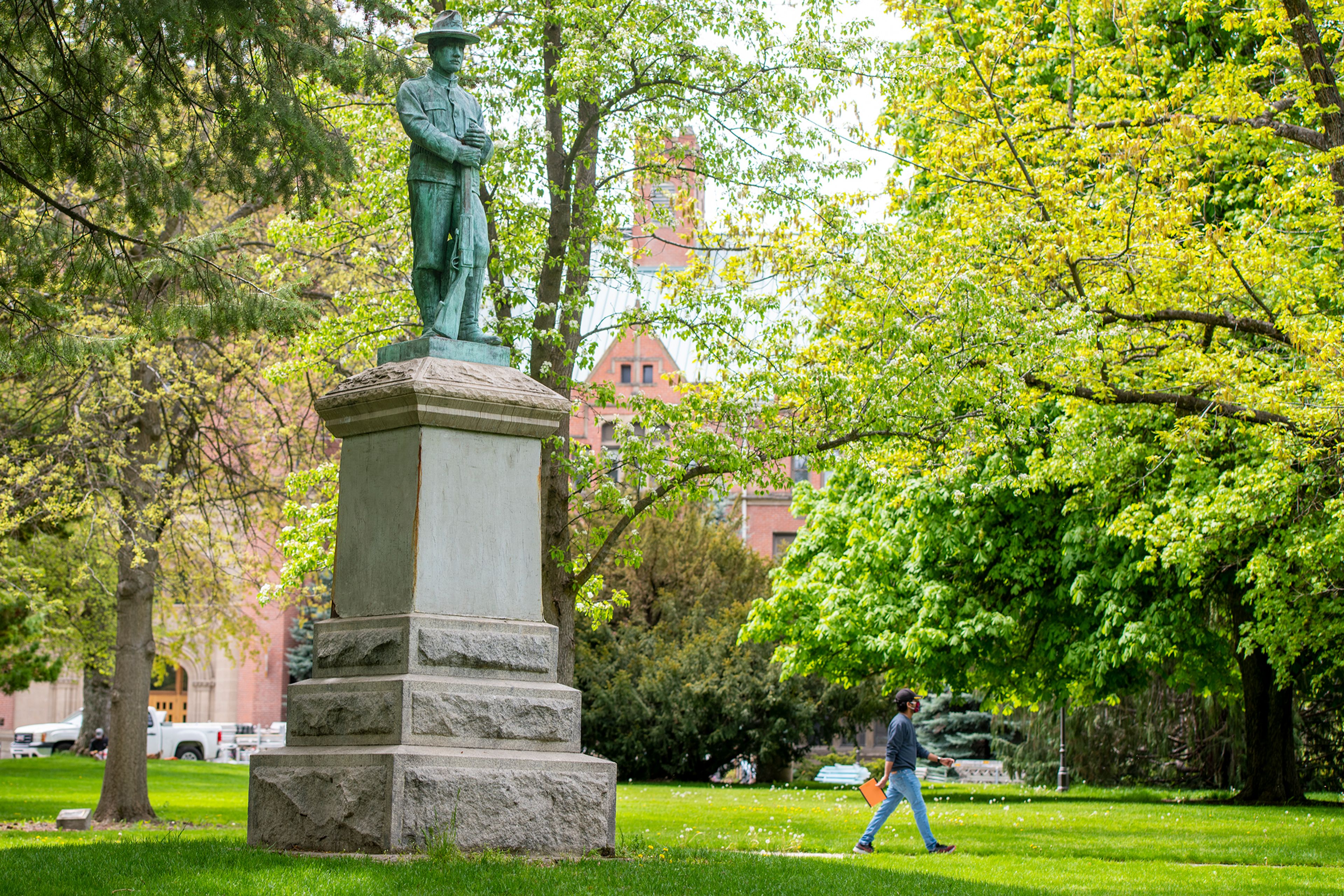 A pedestrian walks past the Ole Hagberg statue on the Administration lawn across from the University of Idaho Administration Building on campus in Moscow.