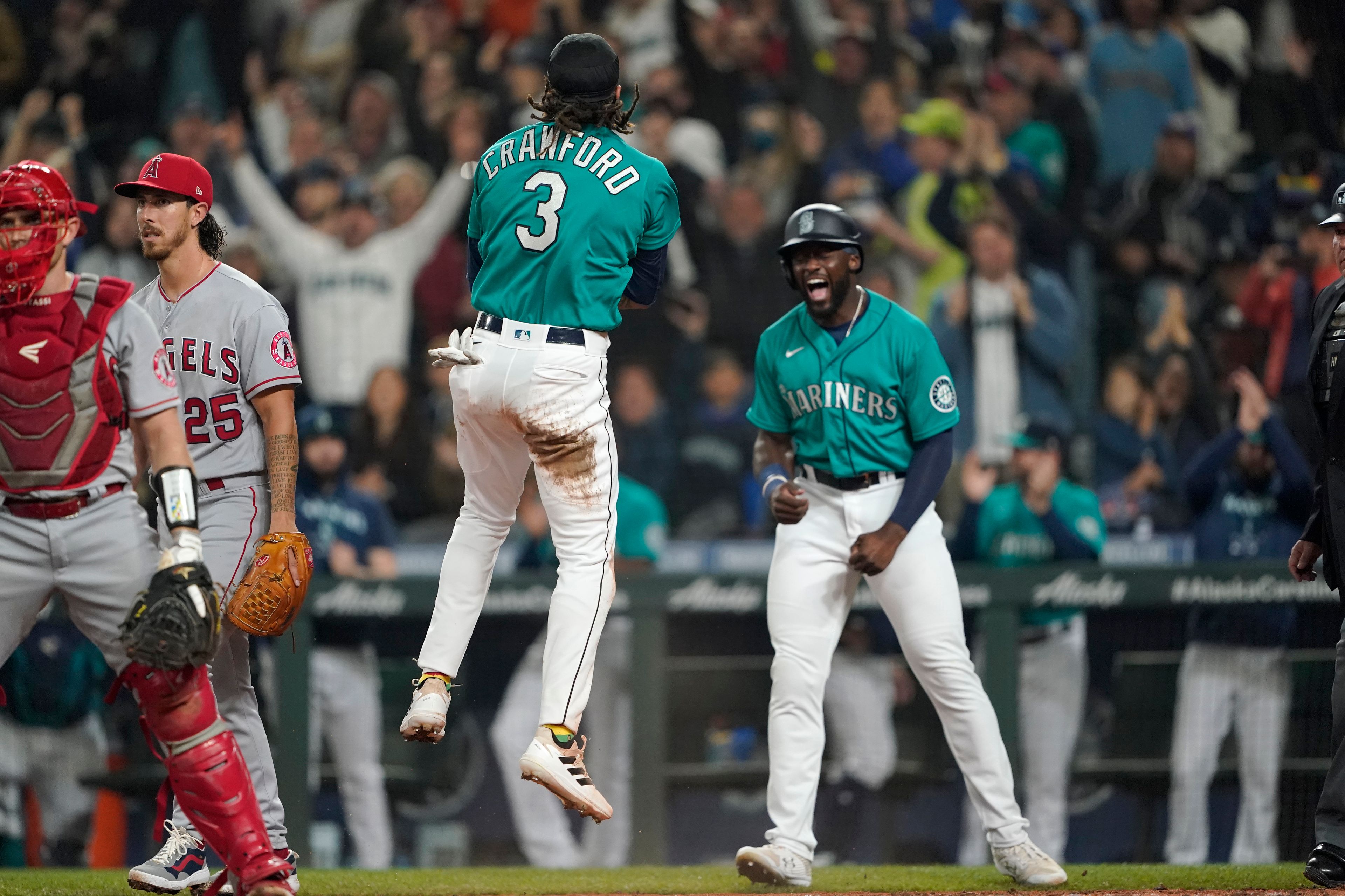 Seattle Mariners' J.P. Crawford (3) celebrates with Taylor Trammell, right, after they both scored on a three-run double hit by Ty France during the fourth inning of a baseball game against the Los Angeles Angels, Friday, June 17, 2022, in Seattle. (AP Photo/Ted S. Warren)