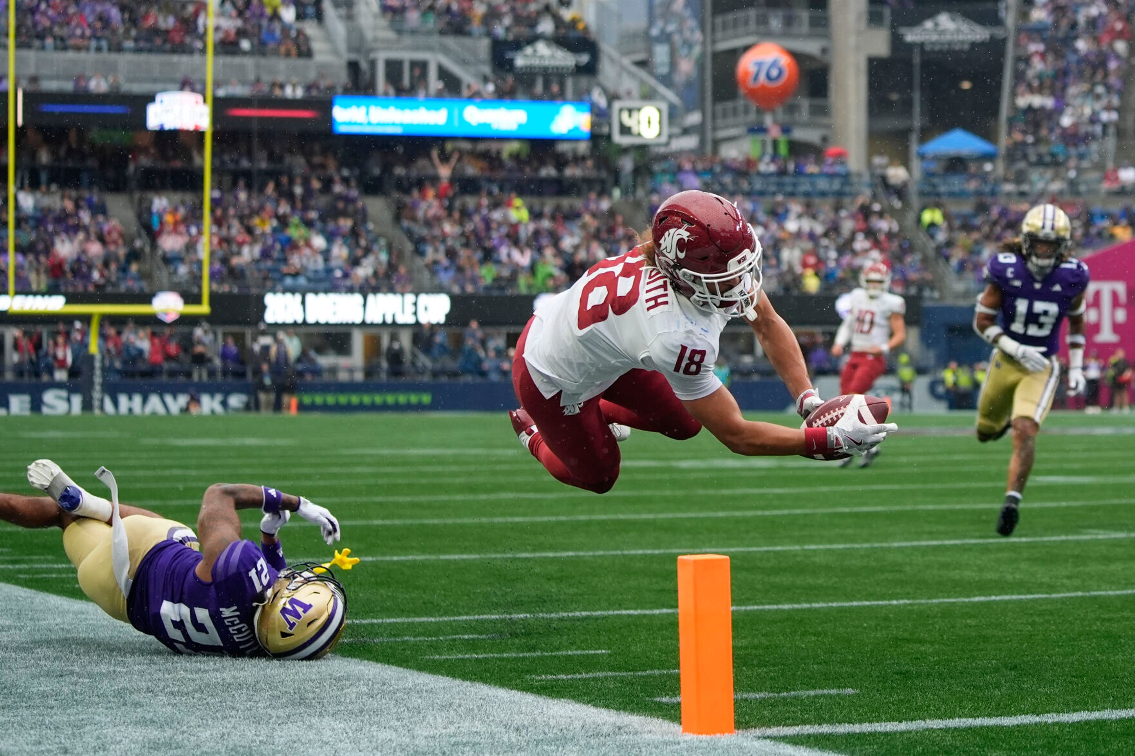 Washington State wide receiver Josh Meredith (18) leaps for a touchdown against Washington defensive back Dyson McCutcheon (21) during the second half of an NCAA college football game Saturday, Sept. 14, 2024, in Seattle. Washington State won 24-19. (AP Photo/Lindsey Wasson)