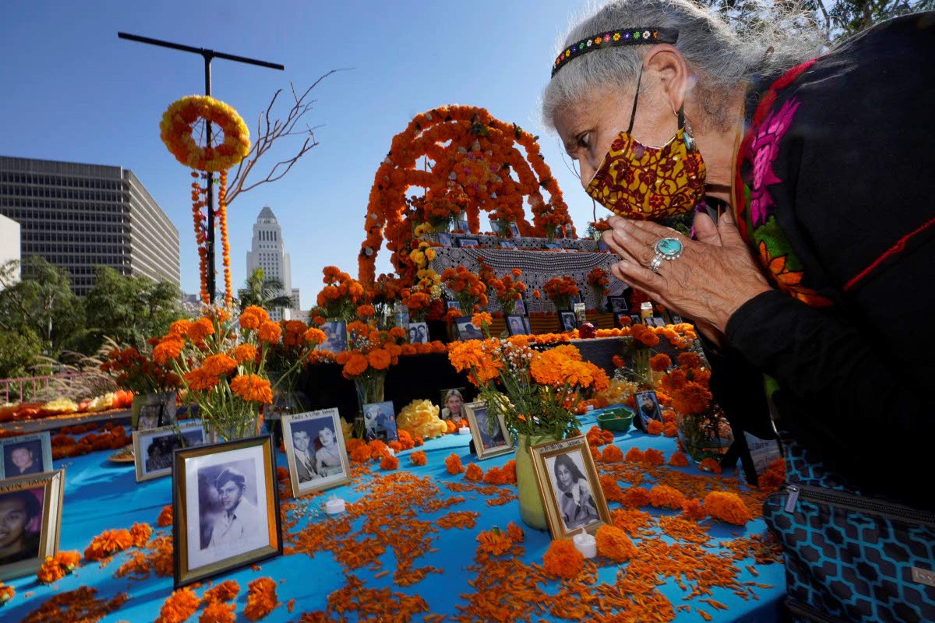 Associated PressOfelia Esparza, 88, from East Los Angles, has brought fresh marigolds, often called “flowers of the dead,” and placed them next to pictures of family members who died in 2020, at an altar for Day of the Dead, titled “2020 Memorial to Our Resilience,” at Grand Park in Los Angeles on Thursday.