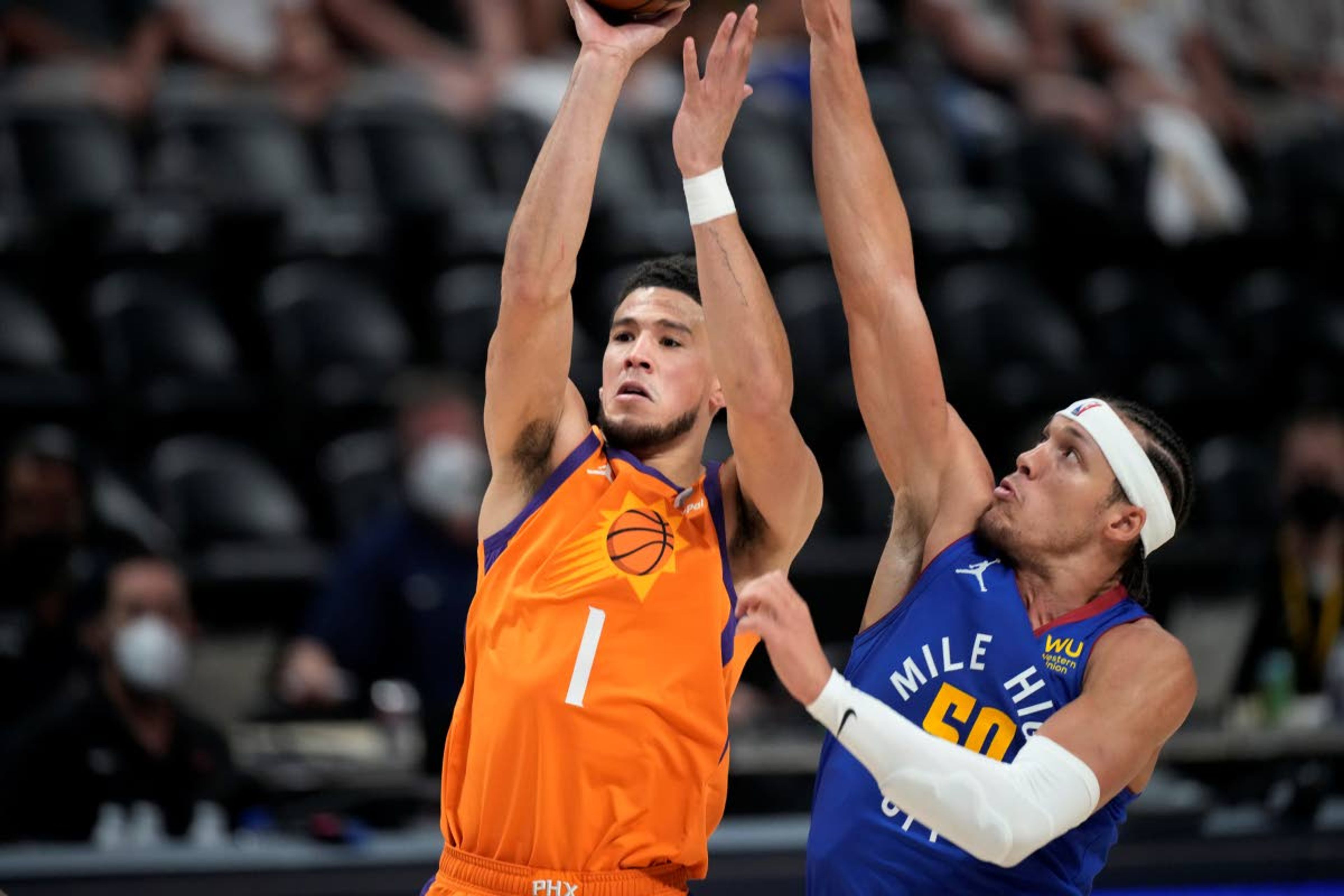 Phoenix Suns guard Devin Booker shoots as Denver Nuggets forward Aaron Gordon defends during the first half of Game 3 of an NBA second-round playoff series Friday, June 11, 2021, in Denver. (AP Photo/David Zalubowski)