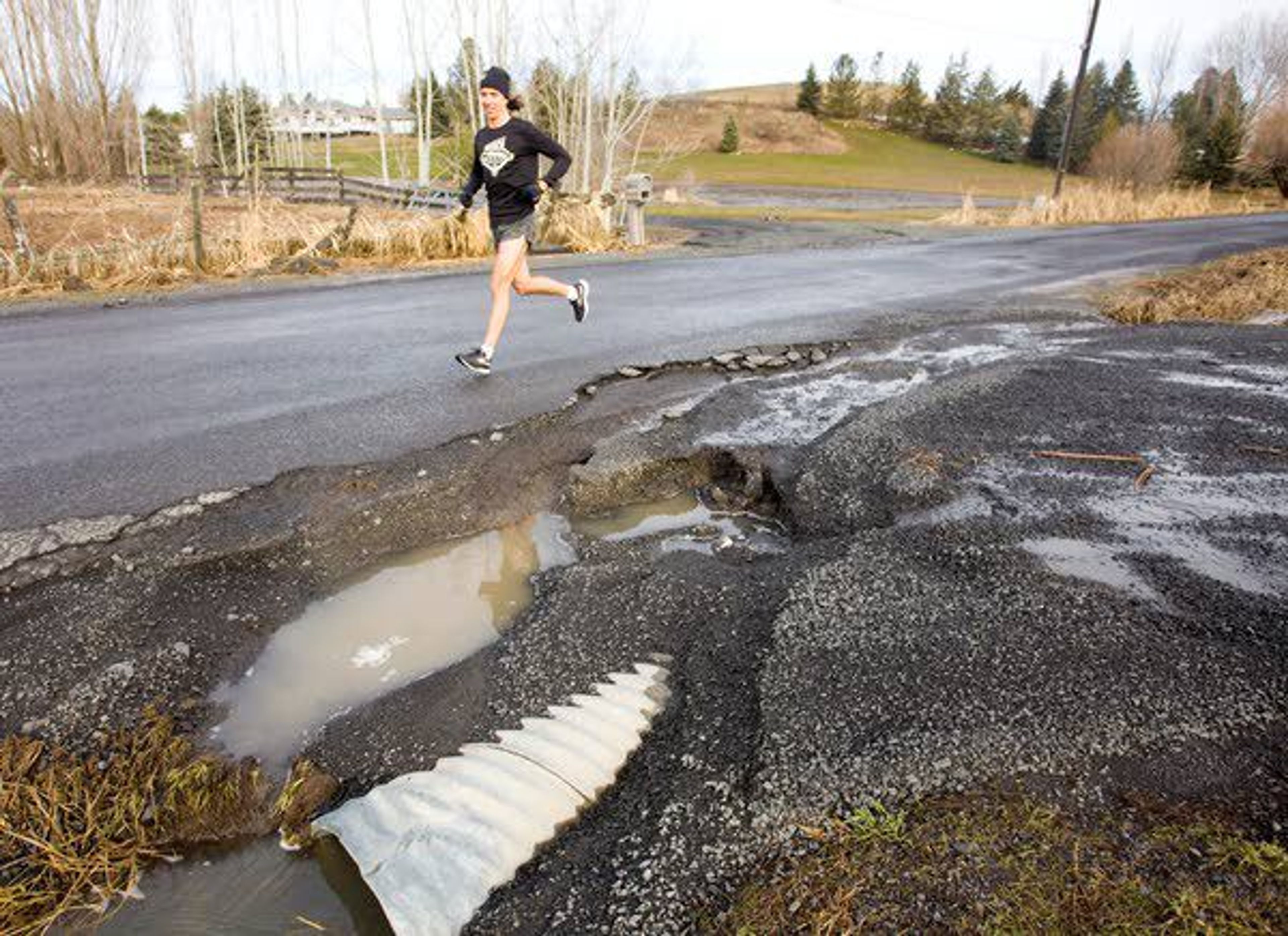 A jogger runs past a culvert that partially washed out on Wednesday on North Polk Street Extension north of Moscow.