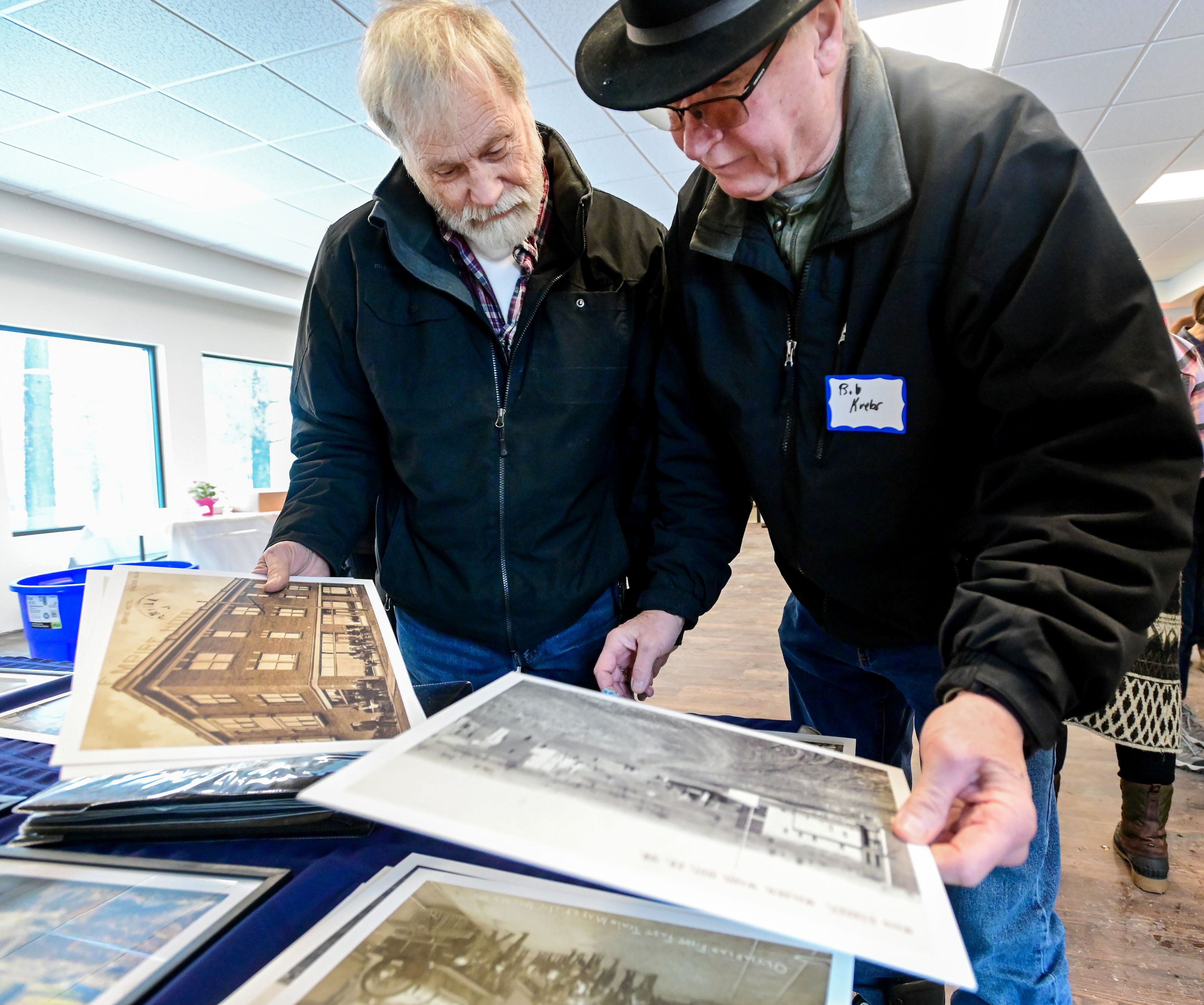 Dave Holmes, left, and Bob Krebs pore over historic photos of Malden, pointing out buildings they remember from childhood, before the ribbon cutting for the town’s new facilities on Thursday.