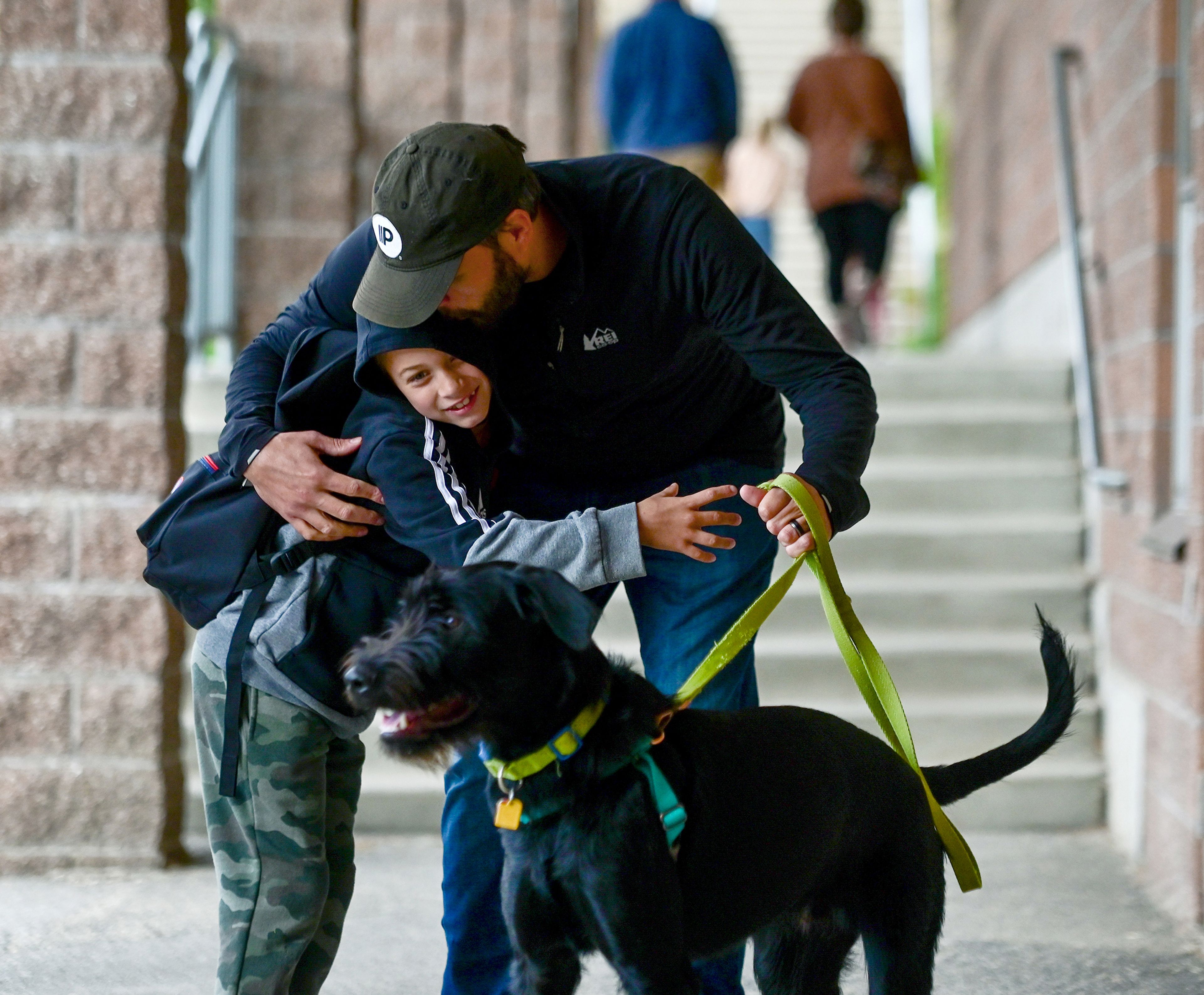 Adam, 7, gives David Royall a hug outside of Jefferson Elementary School before the first day of second grade on Wednesday in Pullman. Dog Charlie Brown received a hug as well before Adam headed inside.