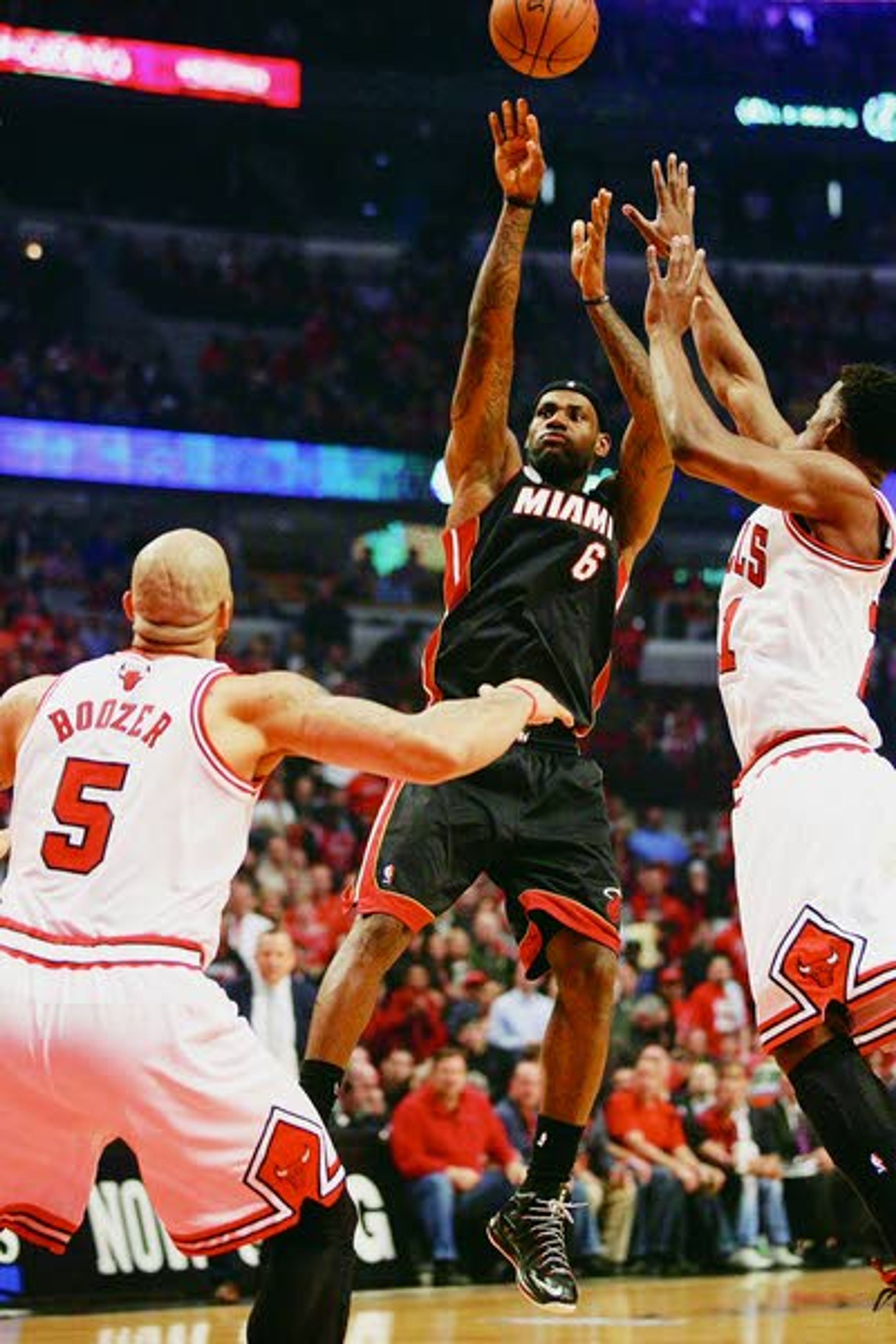 Heat forward LeBron James shoots against Bulls forward Jimmy Butler, right and Chicago Bulls power forward Carlos Boozer (5) during the first half of their Game 3 of the Eastern Conference semifinals Friday in Chicago.