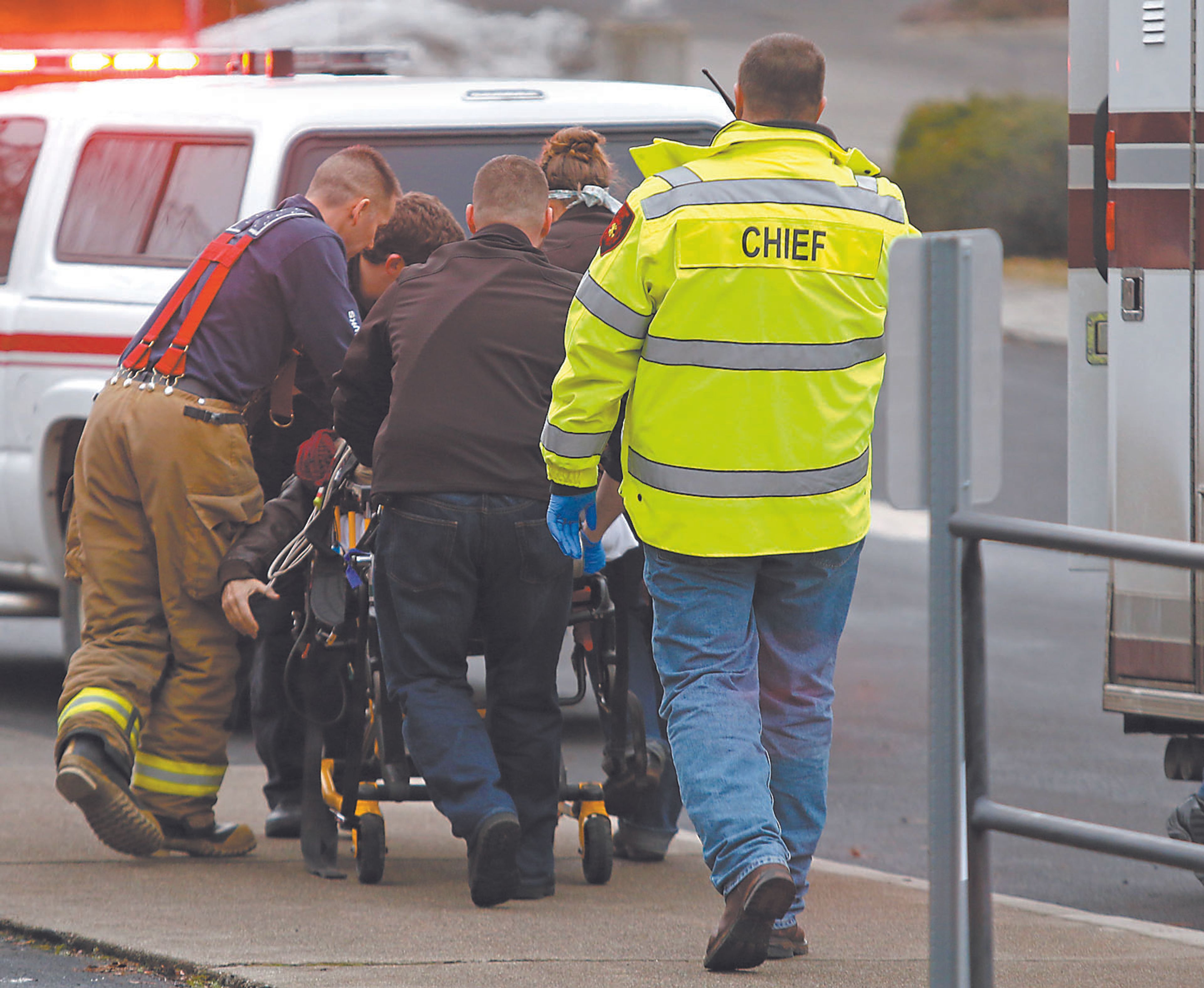 Emergency medical technicians move a gunshot victim to an ambulance outsie an office at the intersection of Jefferson and Third streets in Moscow on Saturday. Two people were shot at the office, and a third was shot at Arby's in Moscow.