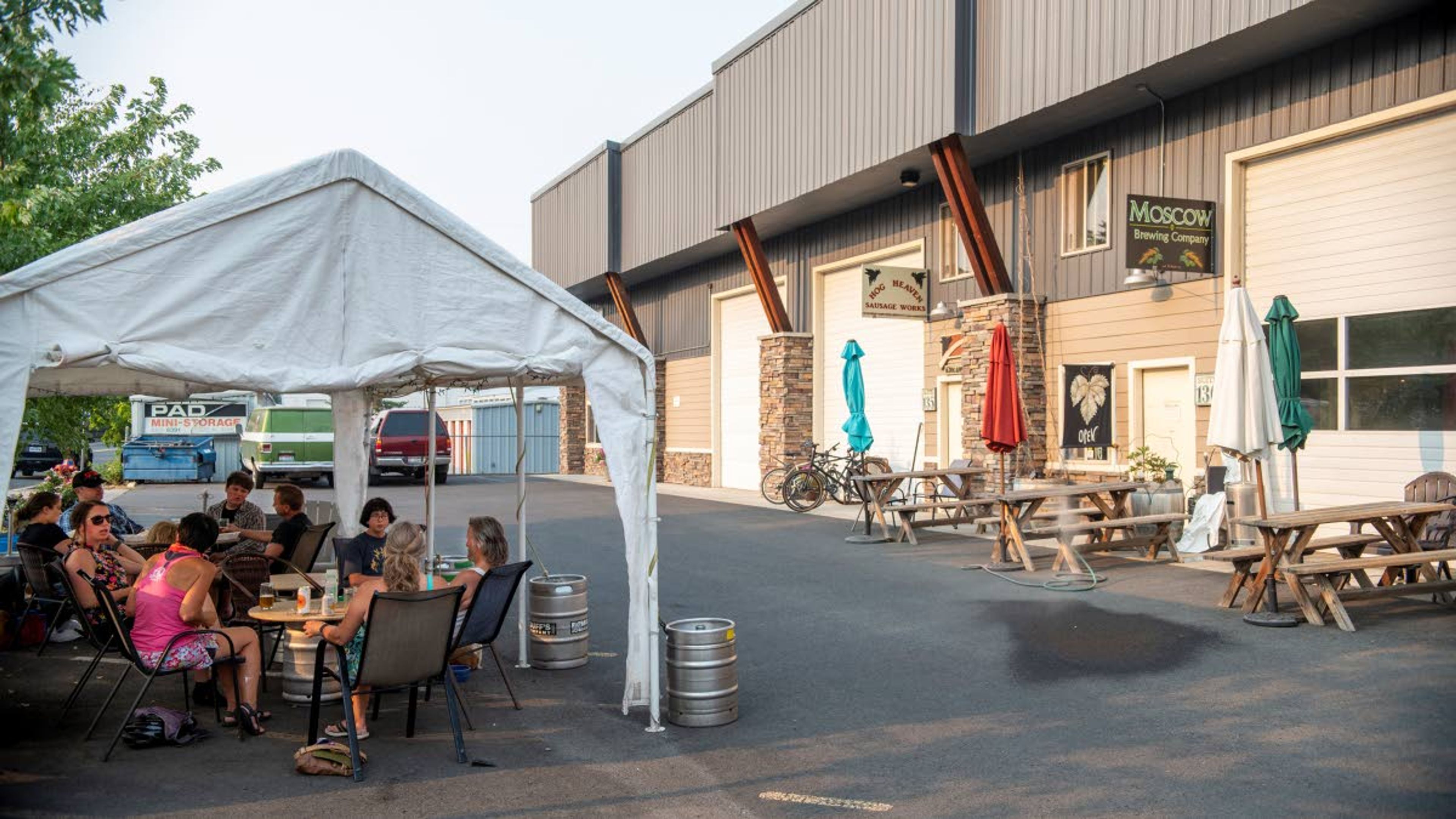 Guests drink beverages while beating the heat under a covered area at Moscow Brewing Company.