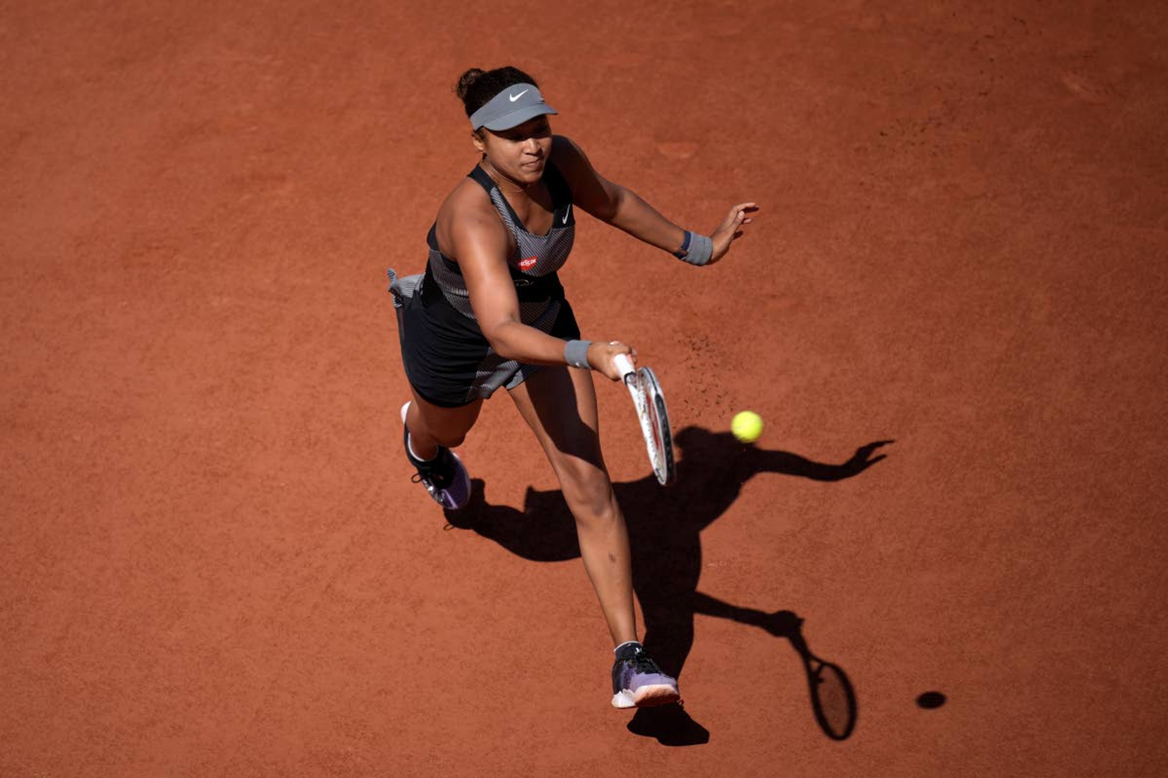 Japan's Naomi Osaka returns the ball to Romania's Patricia Maria Tig during their first round match at the Roland Garros stadium Sunday, May 30, 2021 in Paris. (AP Photo/Christophe Ena)