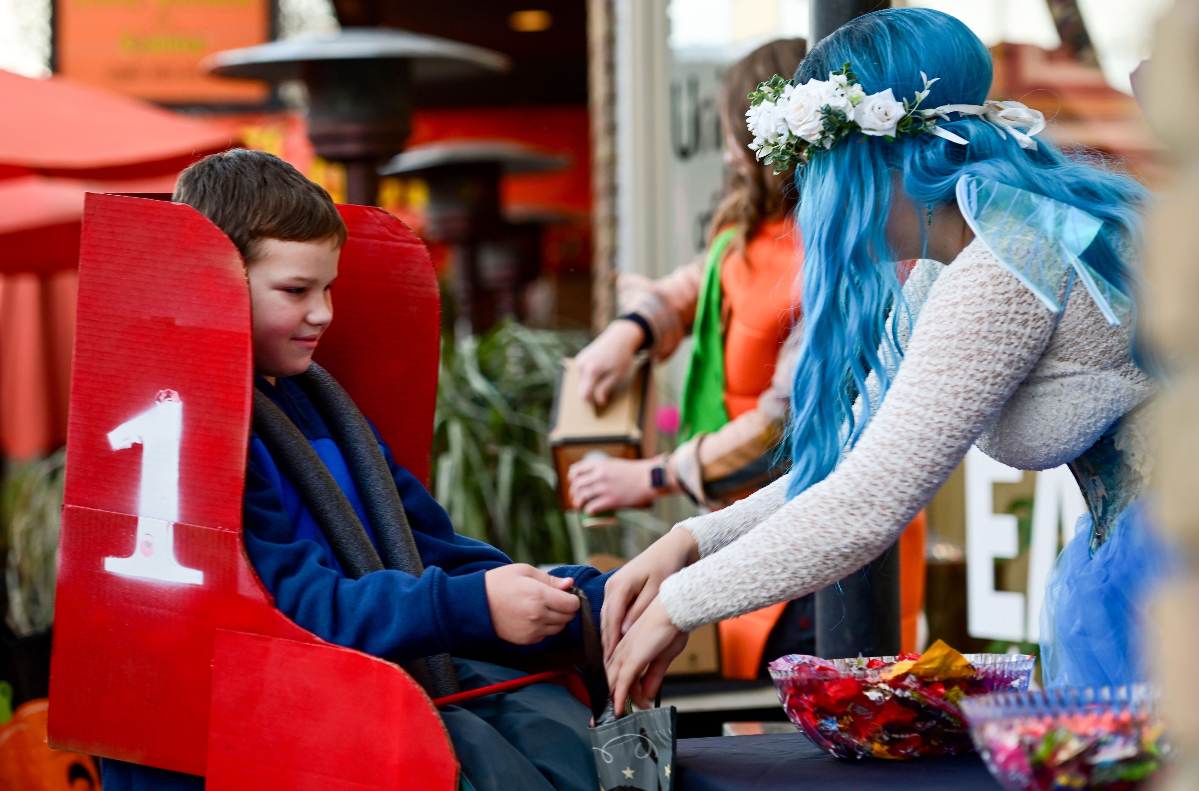 Hugo Morehouse, left, dressed as the first of a four-part rollercoaster seat, receives candy from the Moscow Chamber of Commerce table at the Downtown Trick-or-Treat on Tuesday.