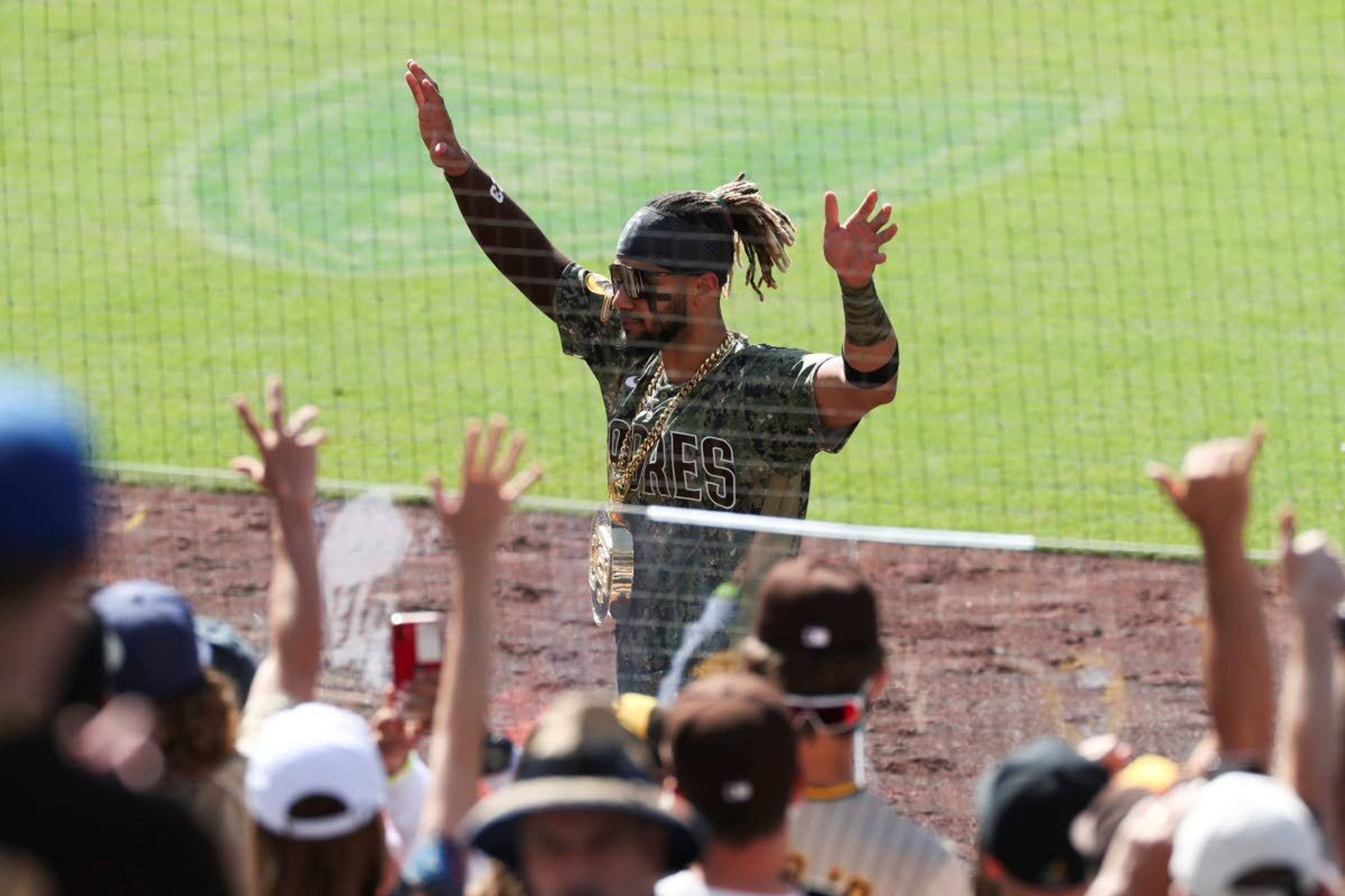 San Diego Padres' Fernando Tatis Jr. waves to fans as he walks off the field wearing an SD medallion following a victory over the Seattle Mariners in a baseball game Sunday, May 23, 2021, in San Diego. (AP Photo/Derrick Tuskan)