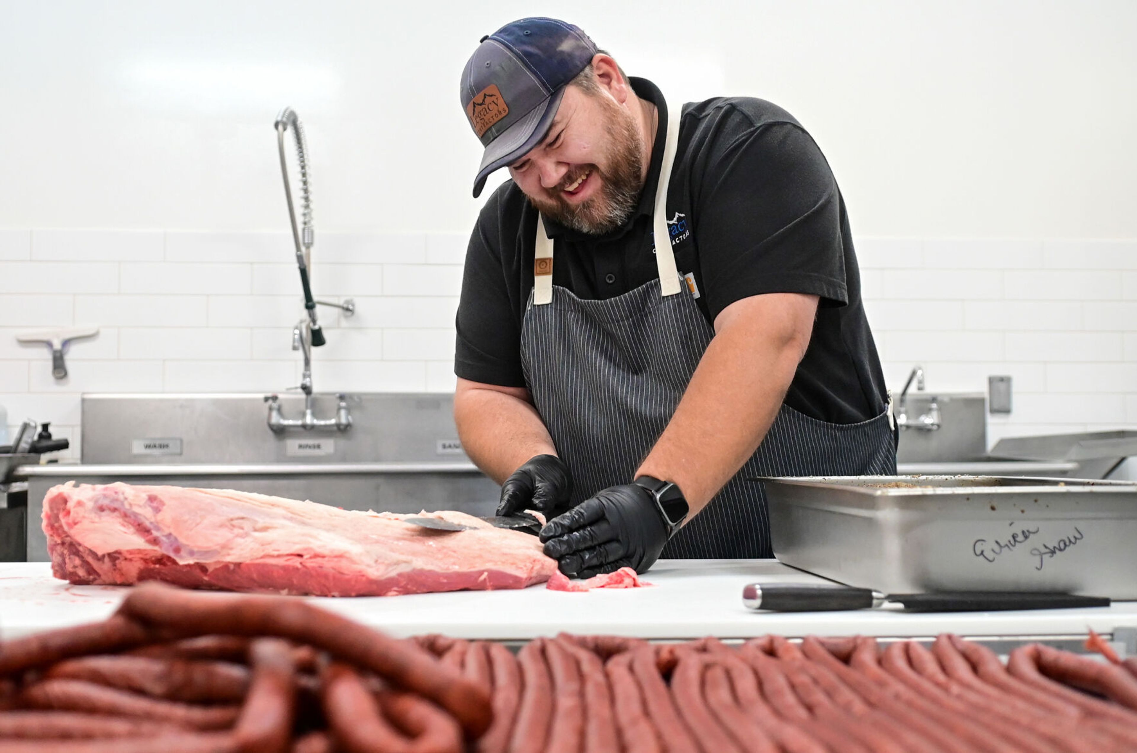 Dale Shaw trims a brisket to prepare it for a nearly 24-hour smoking process on Friday at The Butcher Shop in Deary.