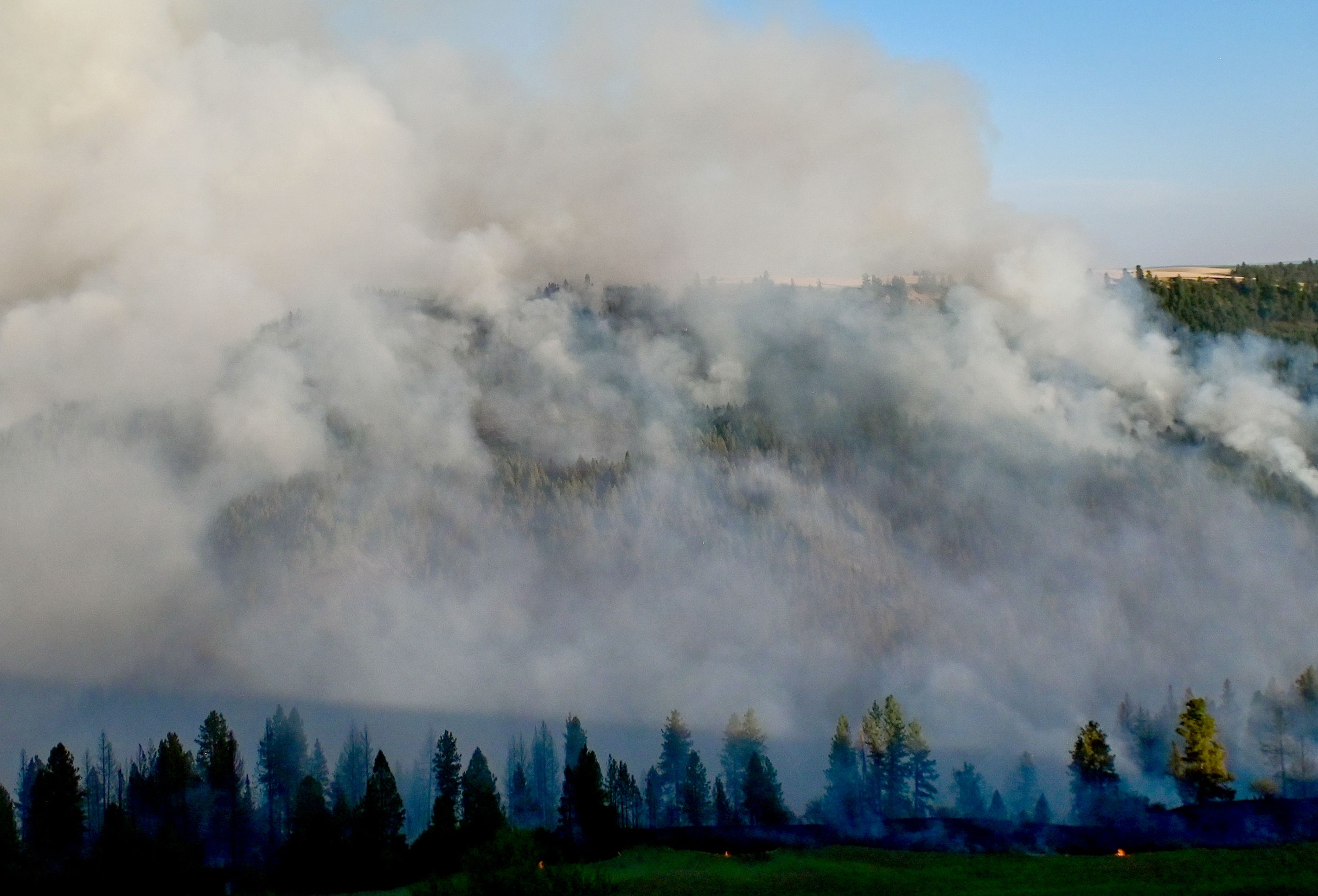 Smoke rises from a canyon in the area of Texas Ridge and Cedar Ridge roads as a wildfire burns near Kendrick on Monday.