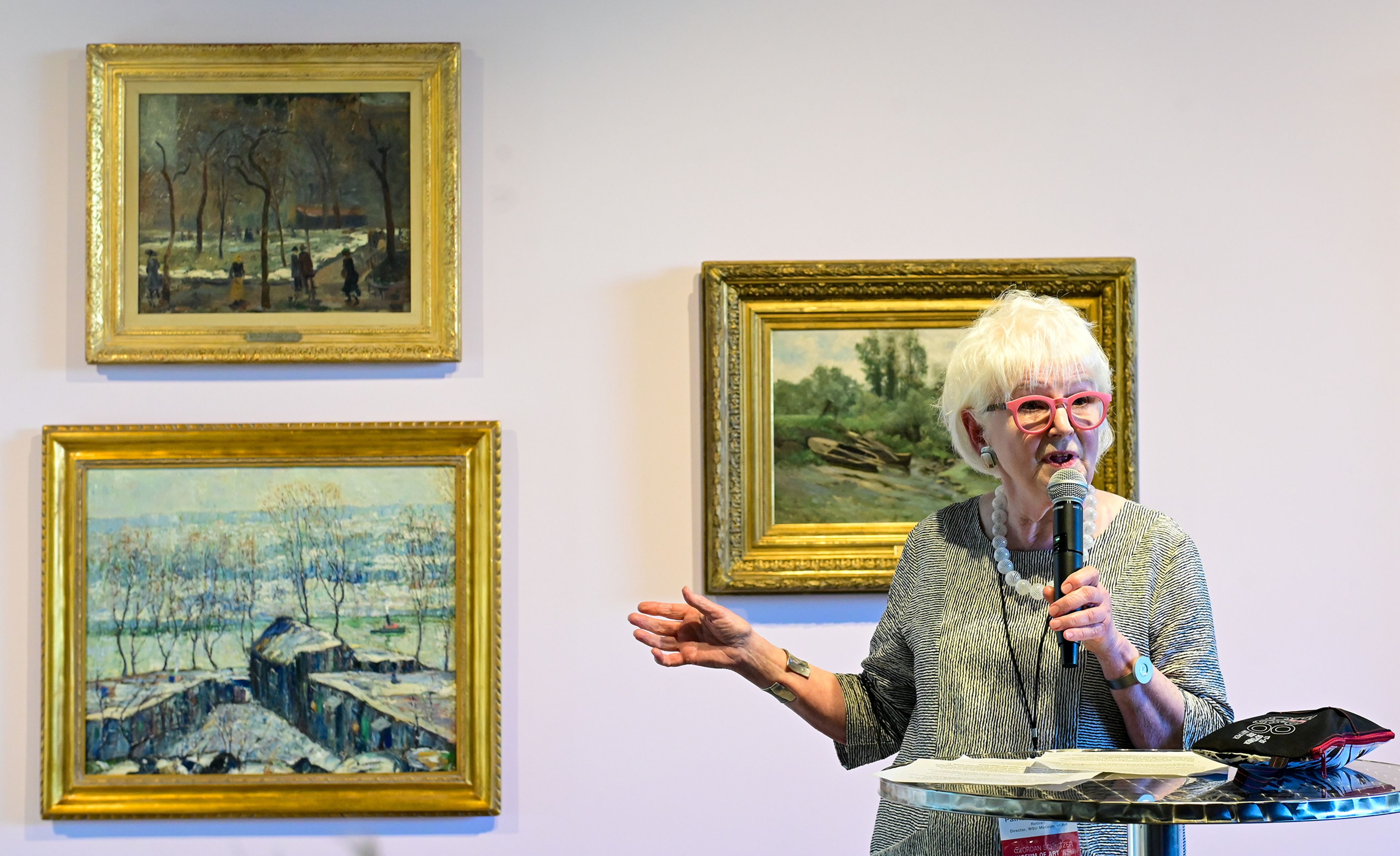 Patricia Watkinson, former Washington State University art museum director during 1980s and 1990s, speaks during a reception and book release to celebrate 50 years since the art museums inception Thursday in Pullman. Behind Watkinson hang pieces from a commemorative exhibit named "Your Collection: Celebrating 50 Years" featuring the museums permanent collection items.