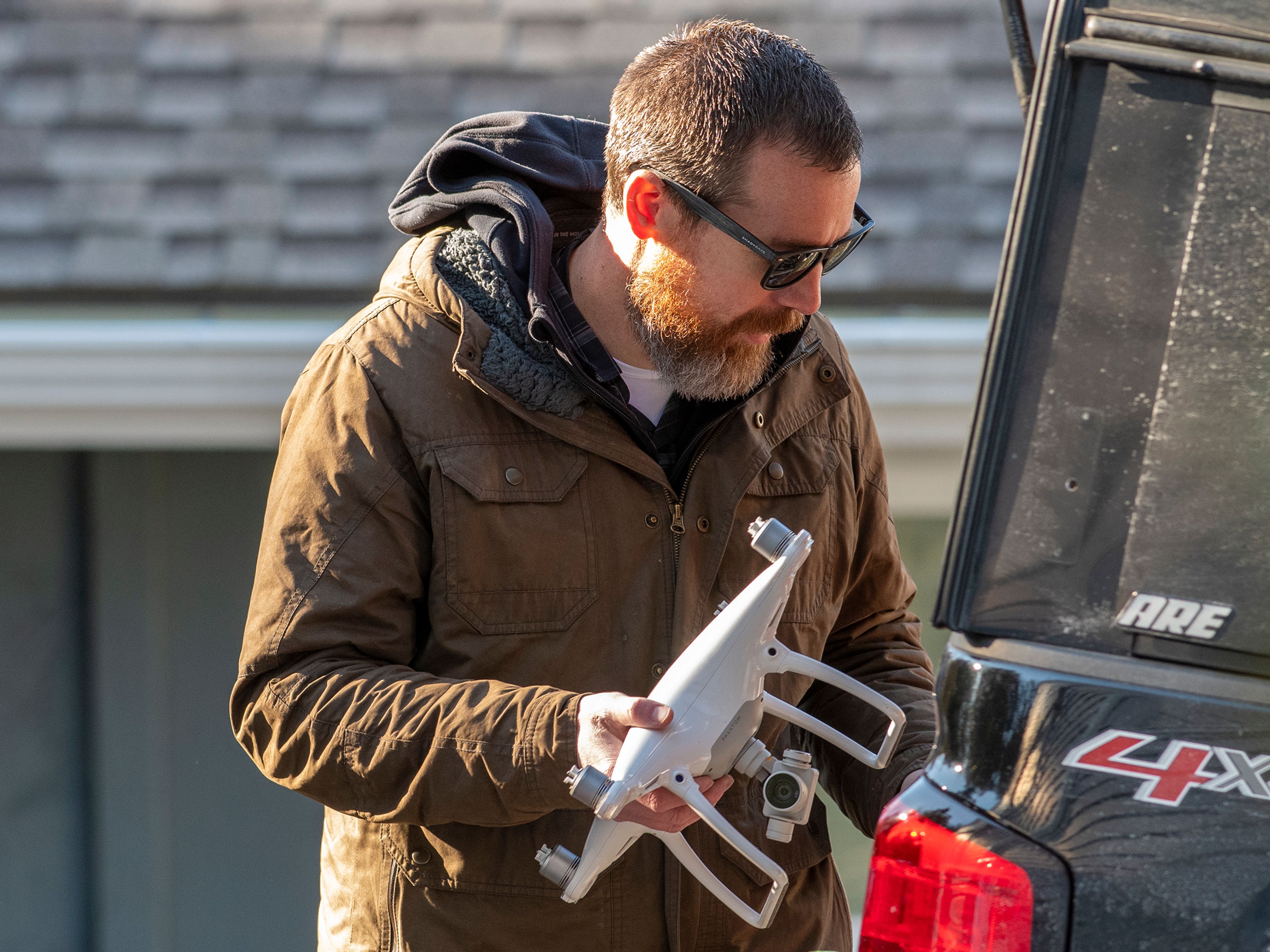 An officers holds a drone while investigating the residence were four UI students were found murdered last weekend in Moscow.