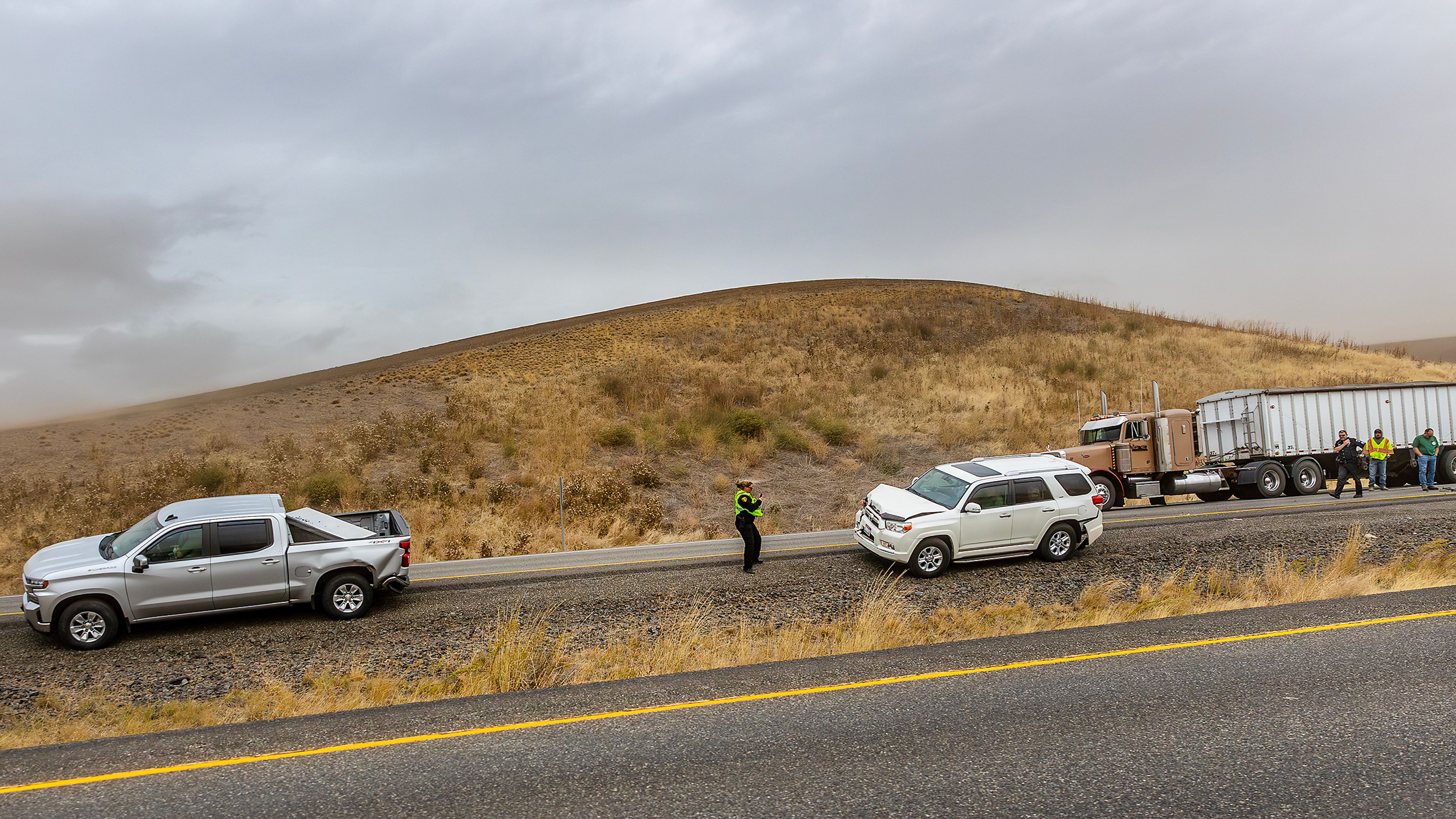 Police respond to a multiple wrecked cars in the southbound lane of U.S. Highway 95 as heavy wind blows dust across the region Friday.