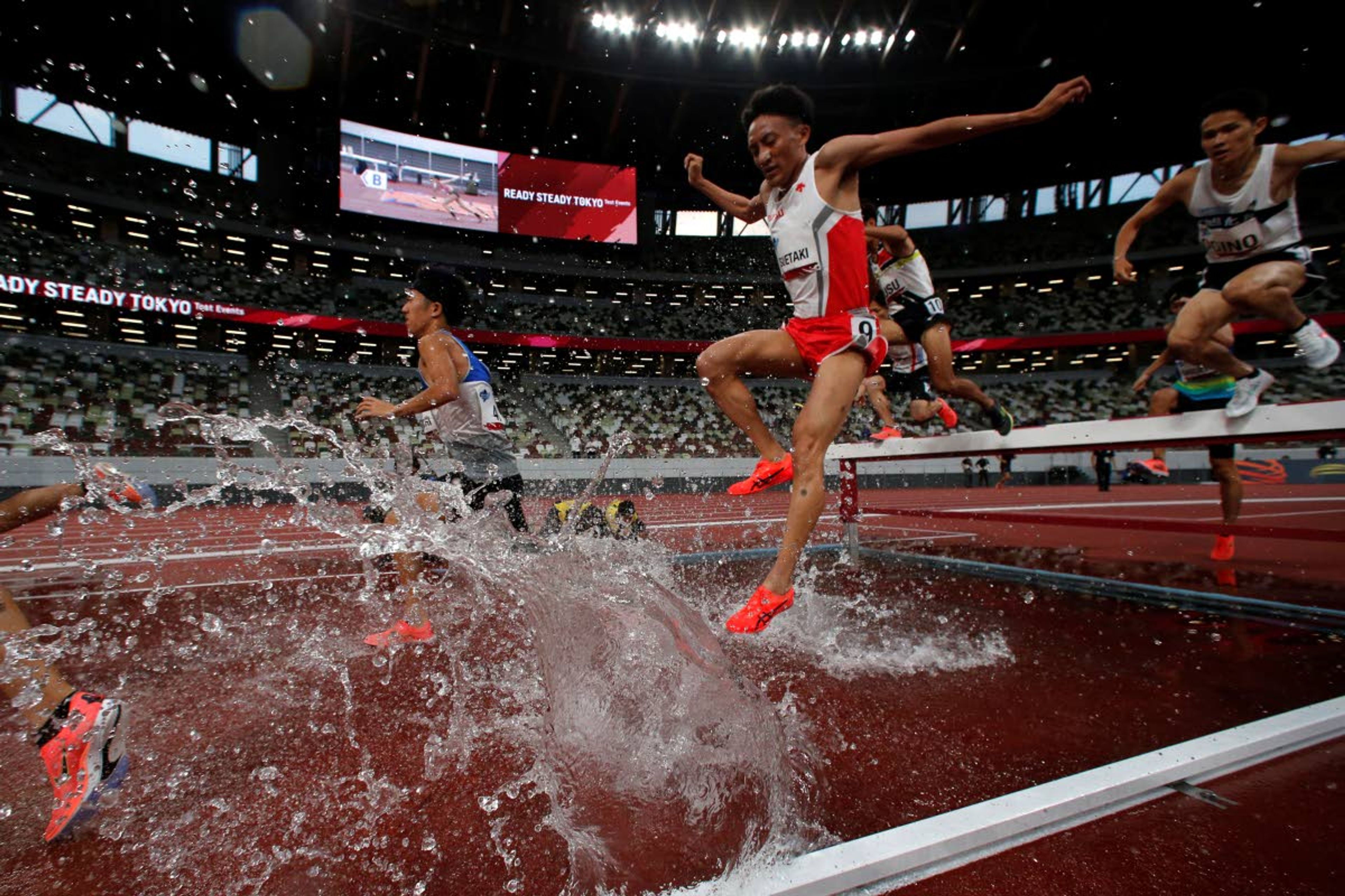 FILE - In this May 9, 2021, file photo, Japanese athletes competes the men's 3,000-meter steeplechase during an athletics test event for Tokyo 2020 Olympics Games at National Stadium in Tokyo. IOC officials say the Tokyo Olympics will open on July 23 and almost nothing now can stop the games from going forward. (AP Photo/Shuji Kajiyama, File)