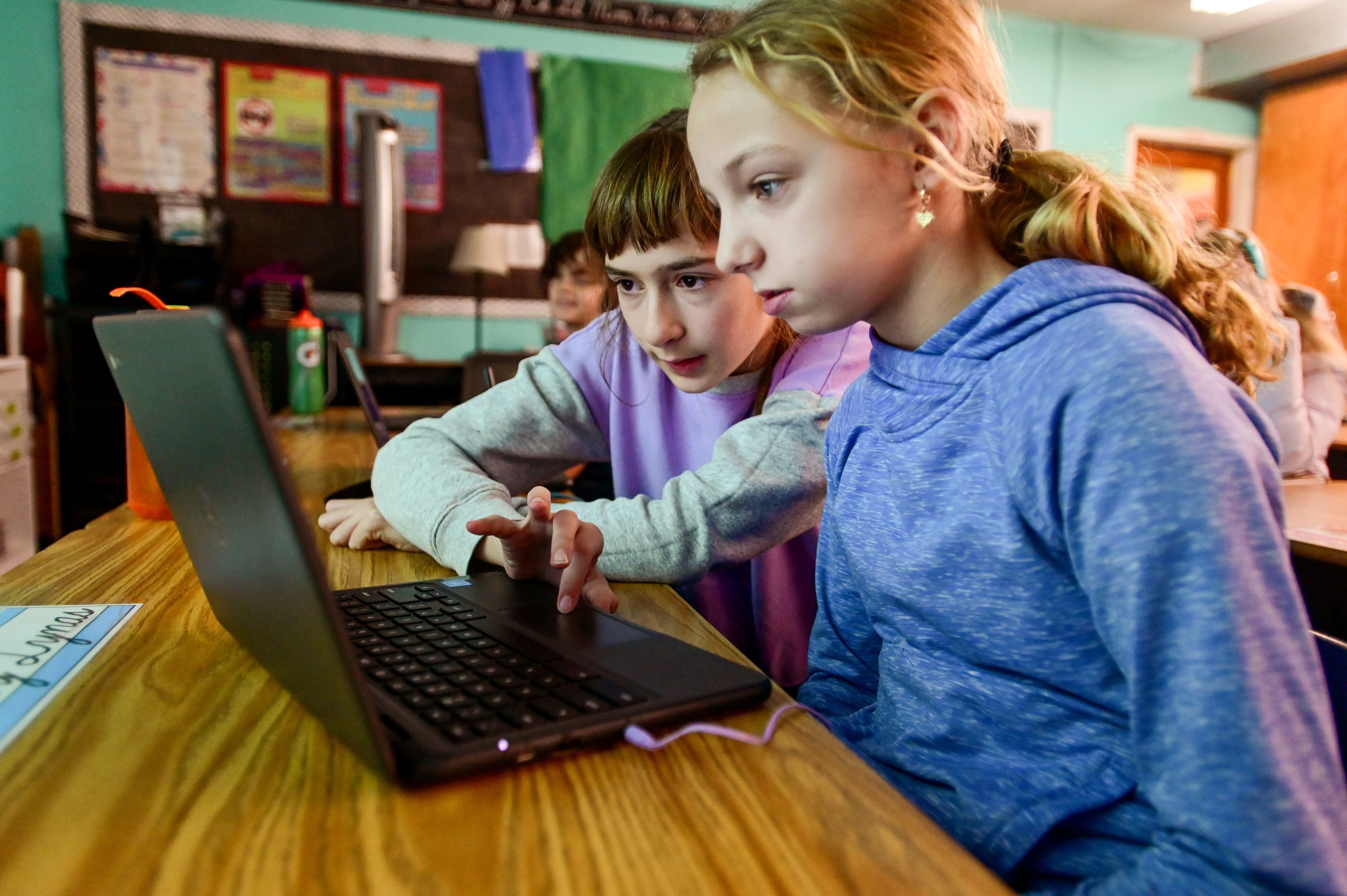 Fifth-graders Gwendolyn Peterson, left, and Bailey Lynas work through part of a coding activity during a visit from Schweitzer Engineering Laboratories engineers for a day-long Hour of Code event at Potlatch Elementary on Tuesday.